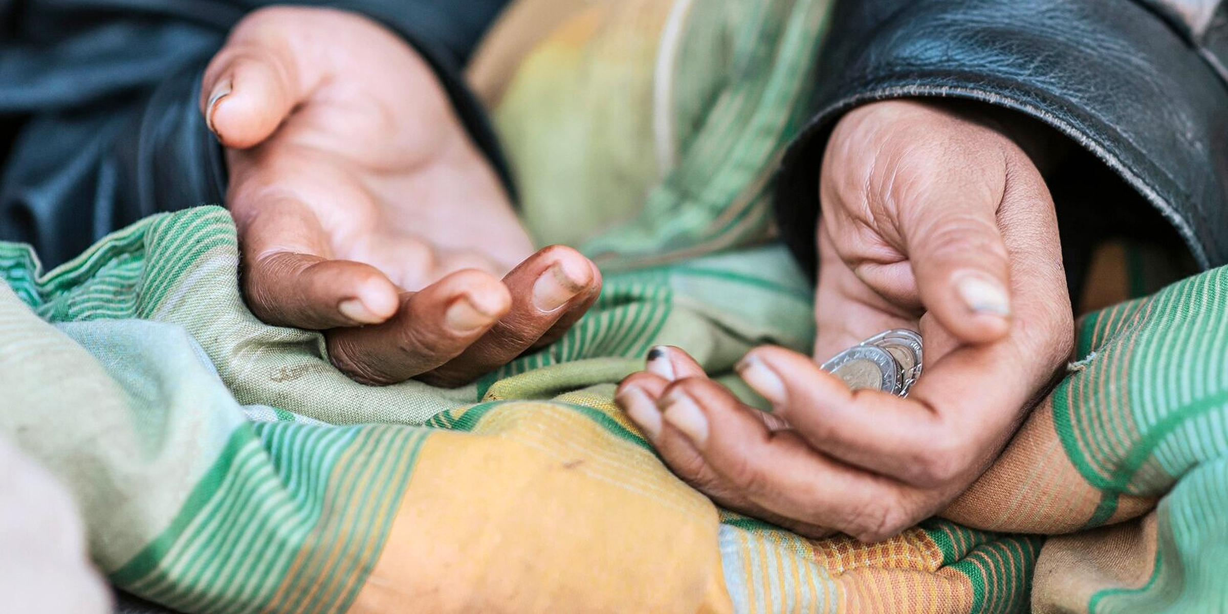 Coins in a homeless woman's hand | Source: Freepik