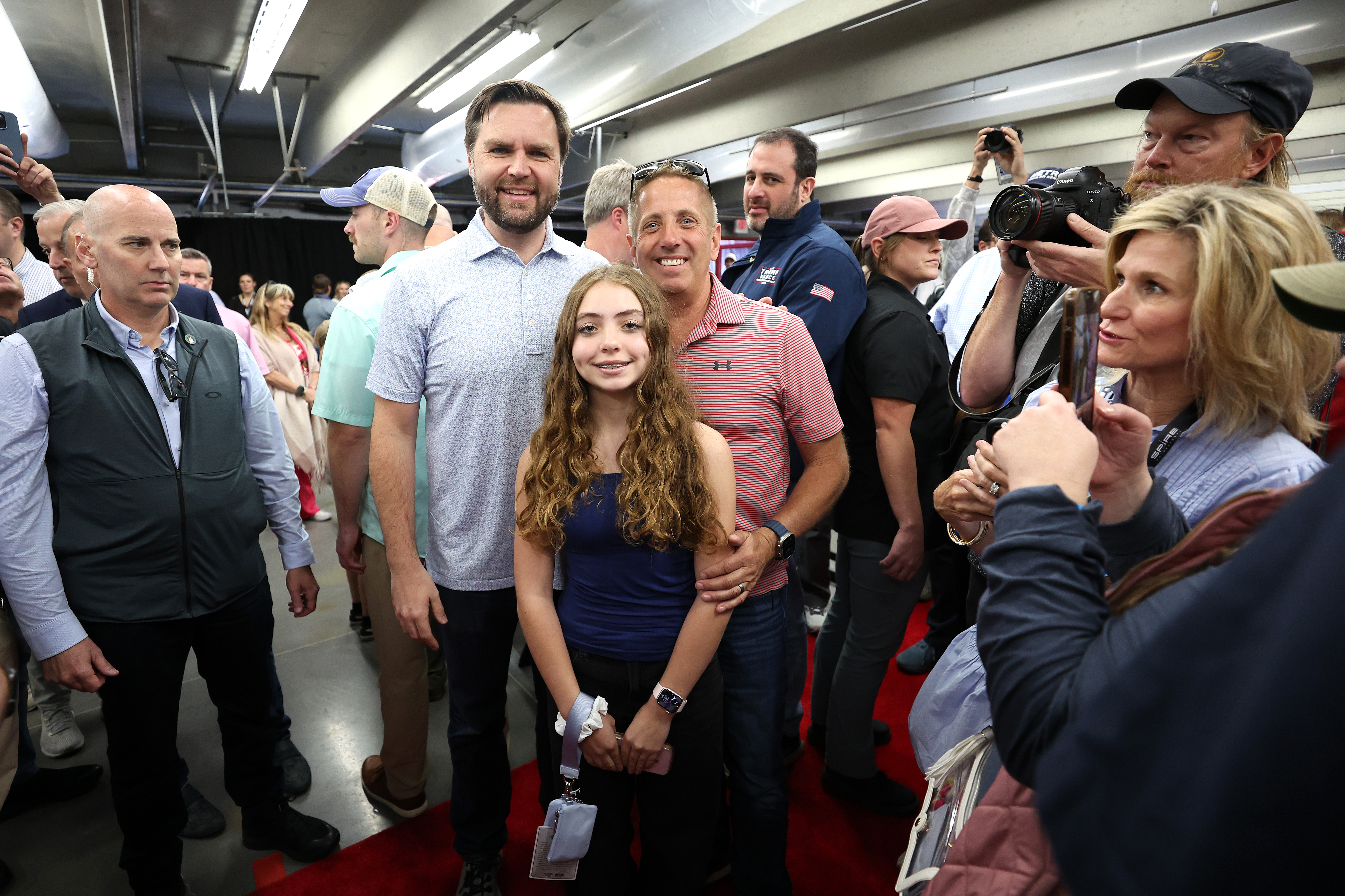 J.D. Vance poses with former NASCAR driver Greg Biffle and his daughter, Emma Elizabeth, before the Bank of America ROVAL 400 at Charlotte Motor Speedway,  North Carolina, on October 13, 2024. | Source: Getty Images