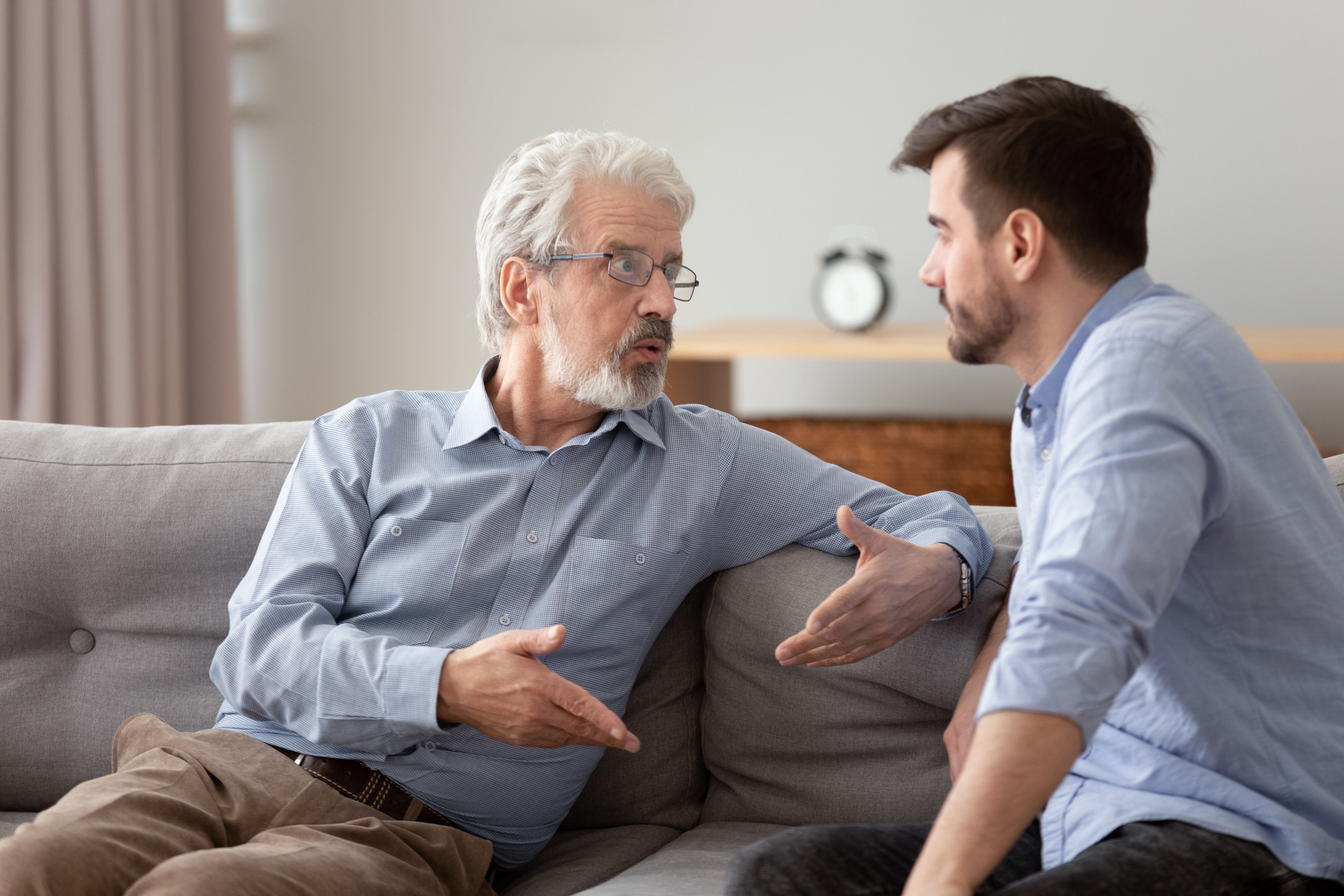 Old man tells something to a young man | Shutterstock