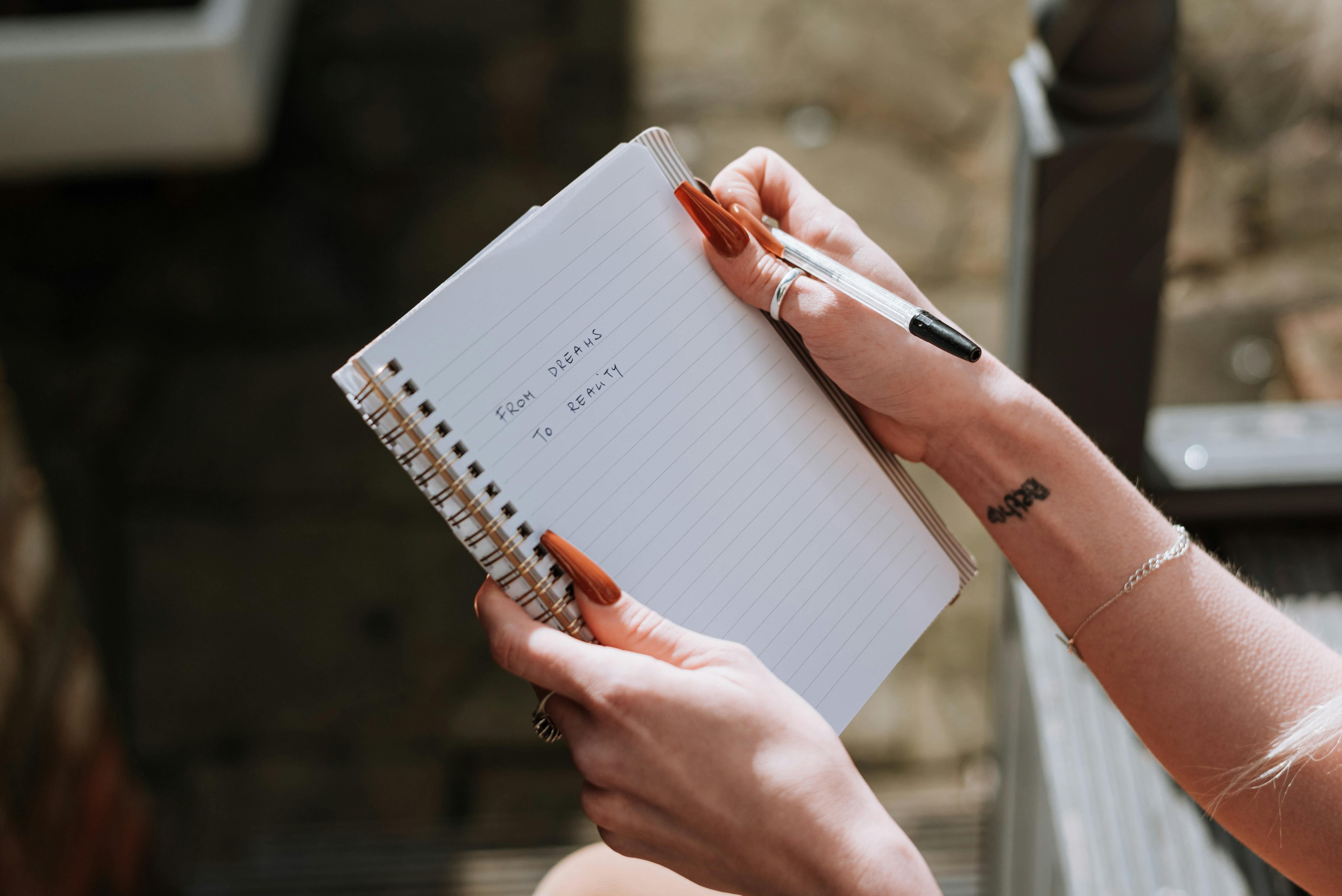 A woman holding up a notebook | Source: Pexels