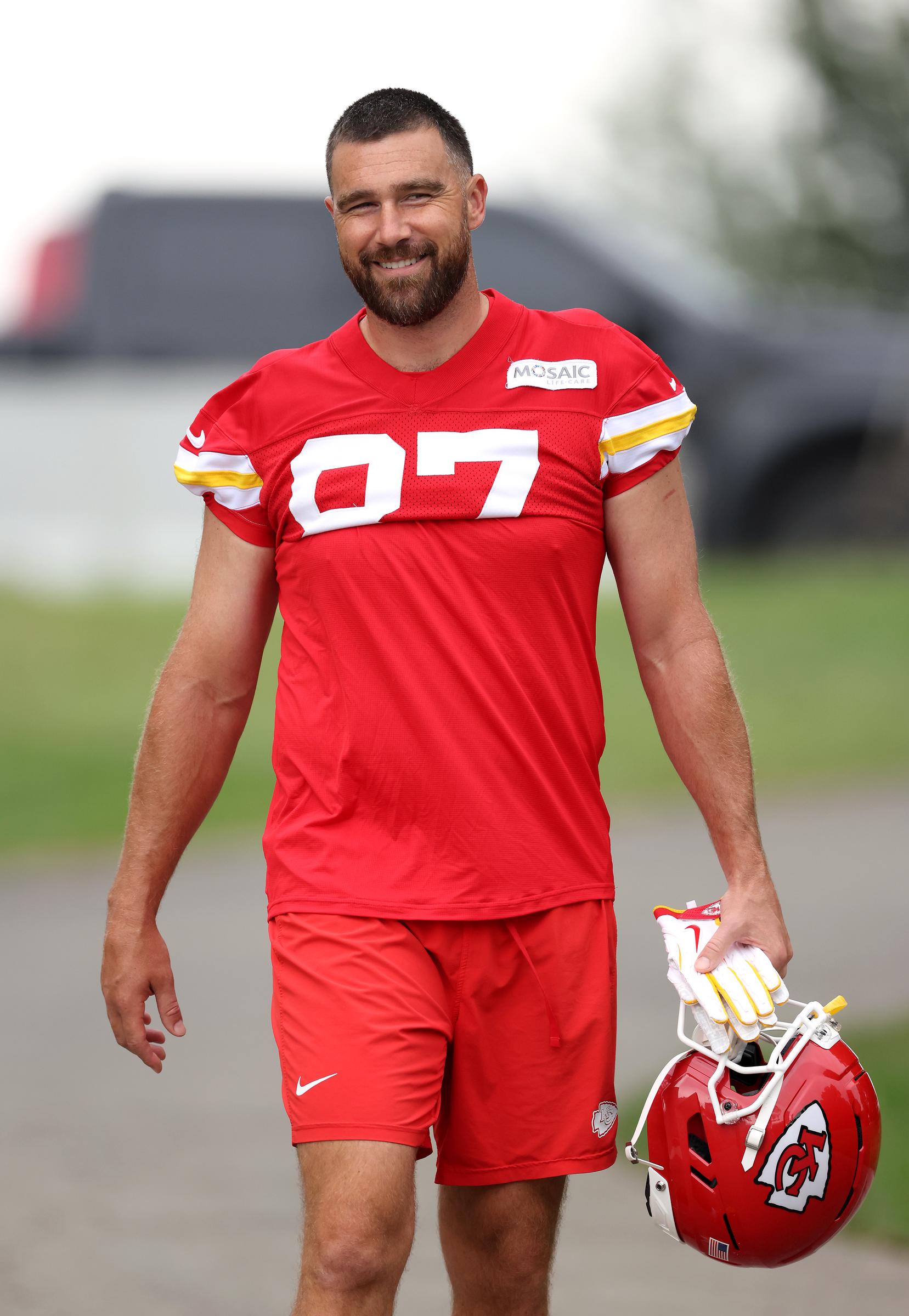 Travis Kelce arrives at the Kansas City Chiefs' training camp in St. Joseph, Missouri, carrying his helmet as he begins preparations for his 14th NFL season—just weeks after marrying Taylor Swift. | Source: Getty Images