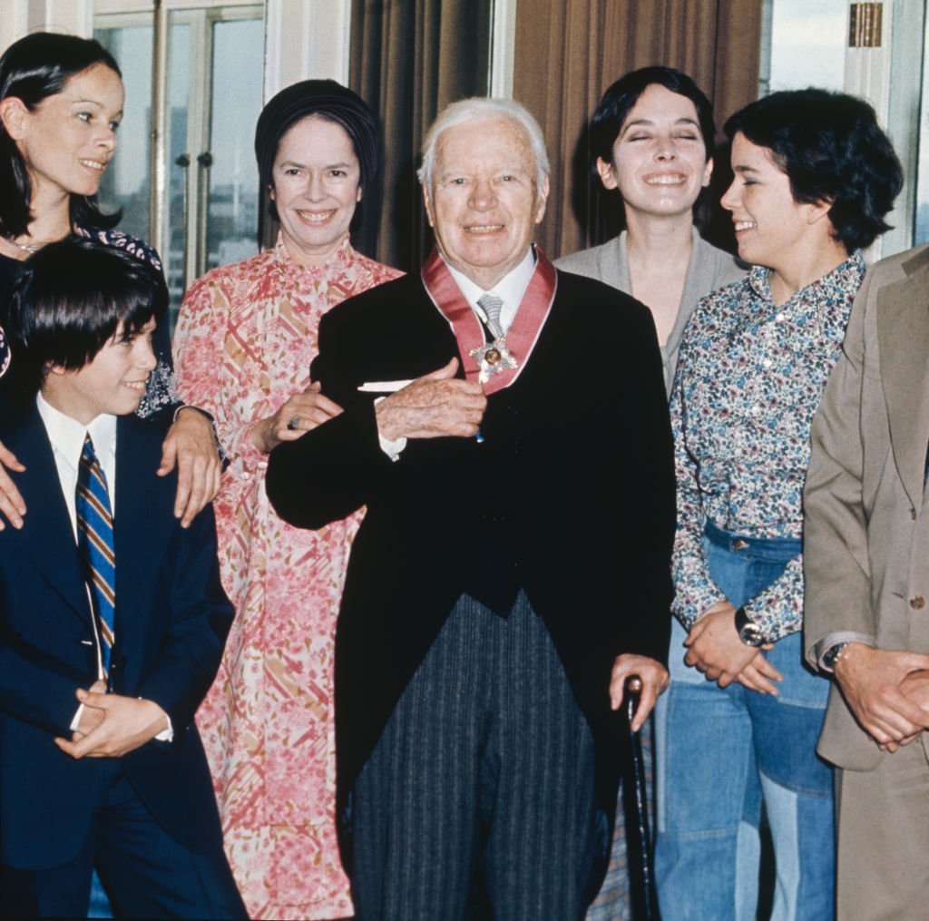 L'acteur et réalisateur Sir Charlie Chaplin (1889 - 1977) avec sa famille à l'hôtel Savoy à Londres, après avoir reçu un KBE, le 4 mars 1975. De gauche à droite, sa fille Geraldine, son fils Christopher, sa femme Oona, Chaplin lui-même, et ses filles Josephine et Annie (Annette). | Photo : Getty Images.