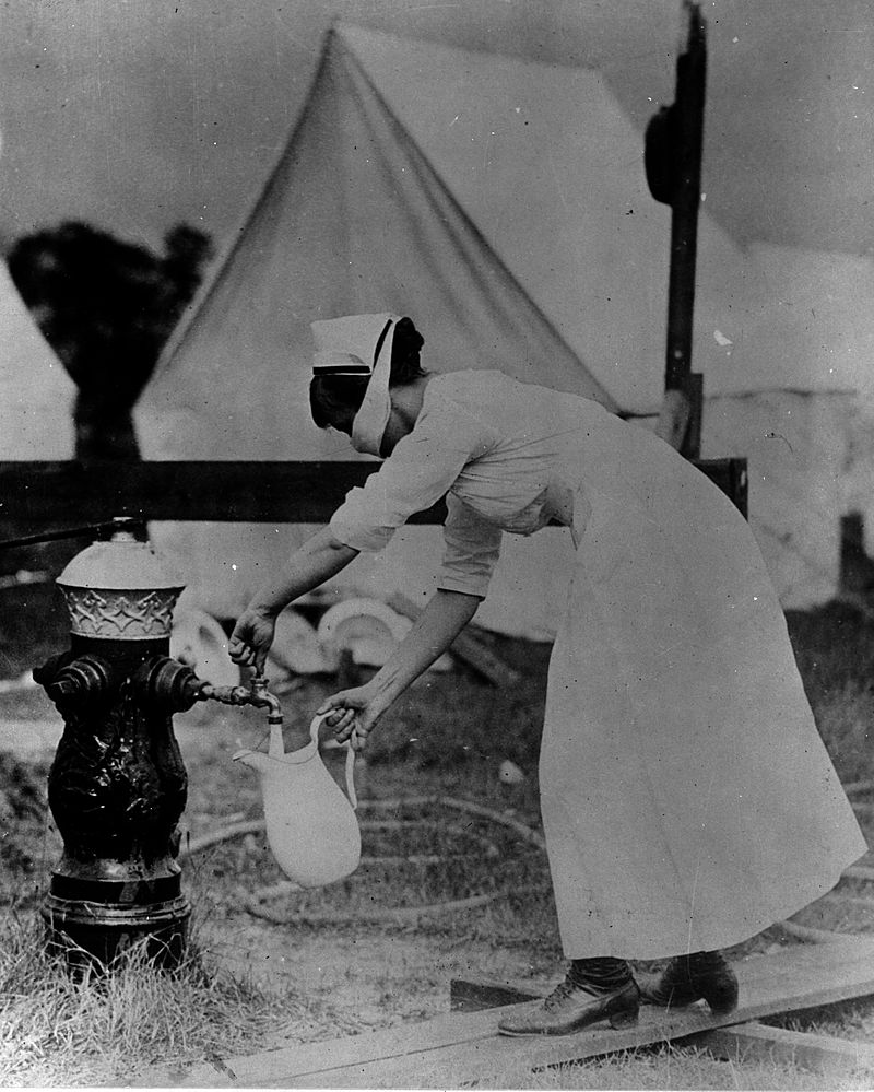 Enfermera carga agua de una boca de incendio con un tapabocas, 1918 | Foto: Wikimedia Commons