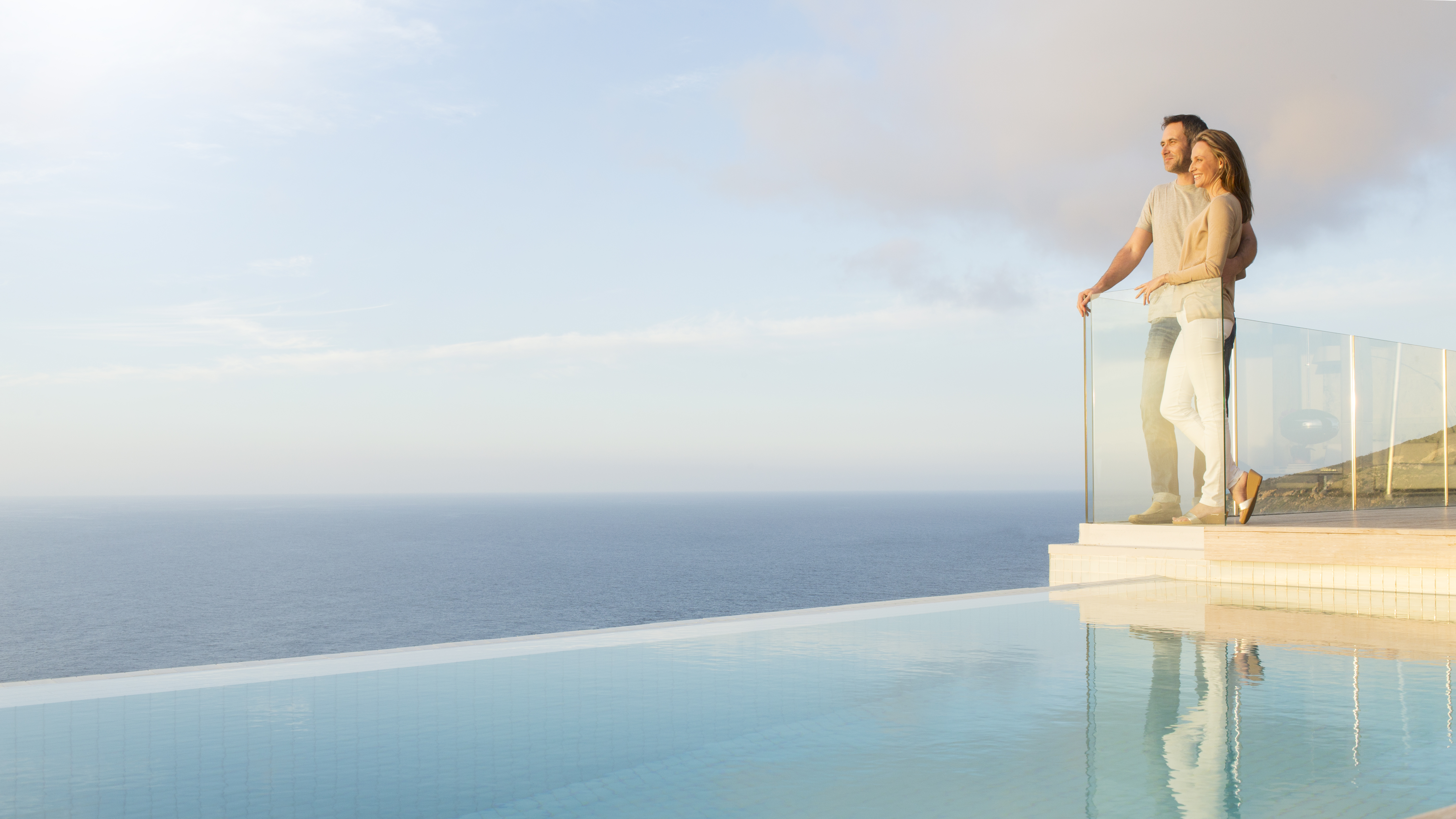 Couple overlooking ocean from modern balcony | Source: Getty Images