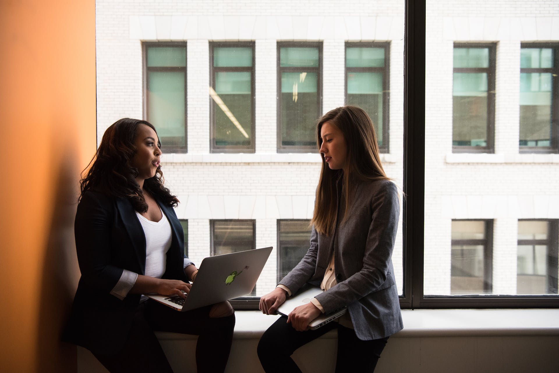 Two women chatting at their workplace | Source: Pexels