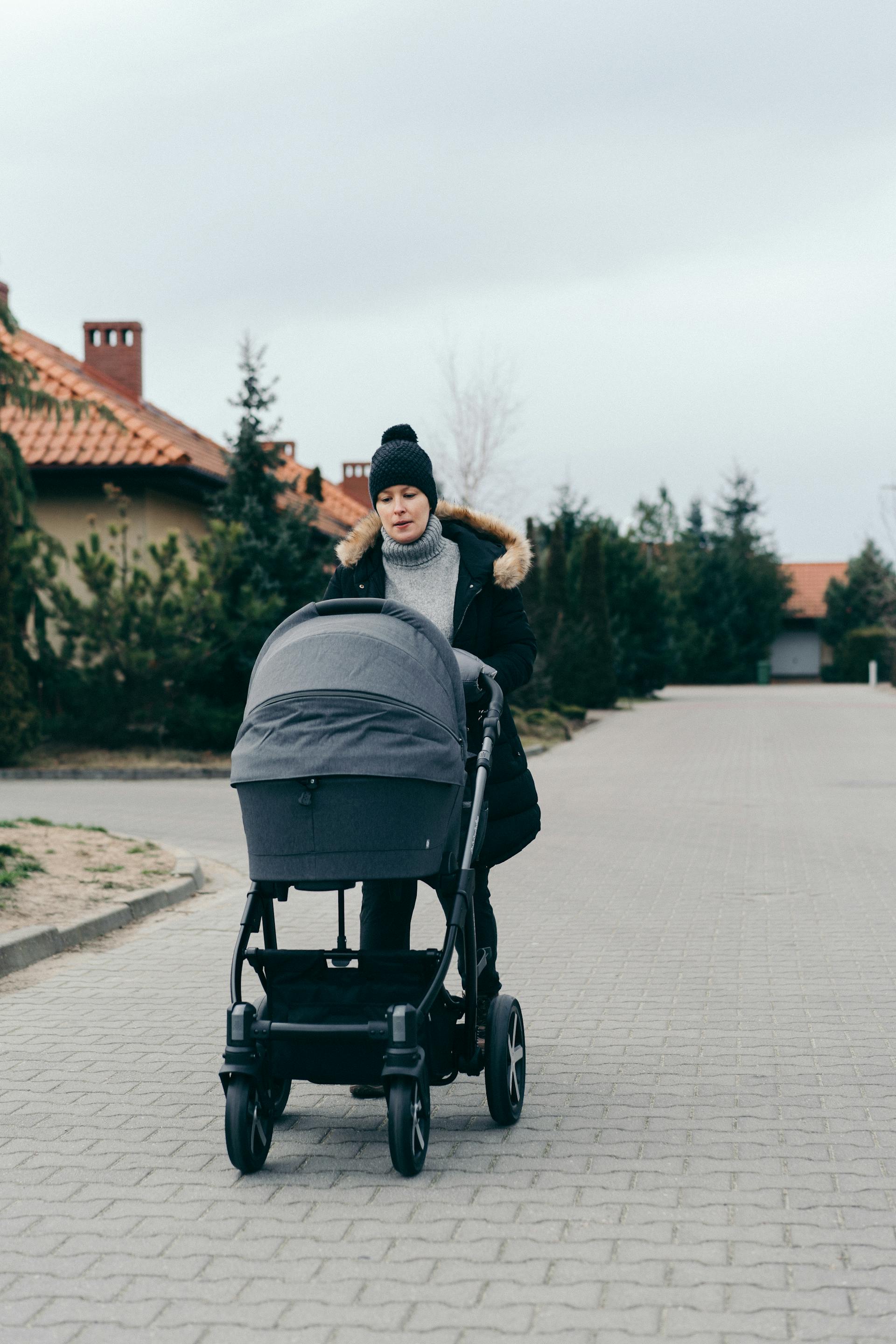 A woman pushing a baby stroller | Source: Pexels