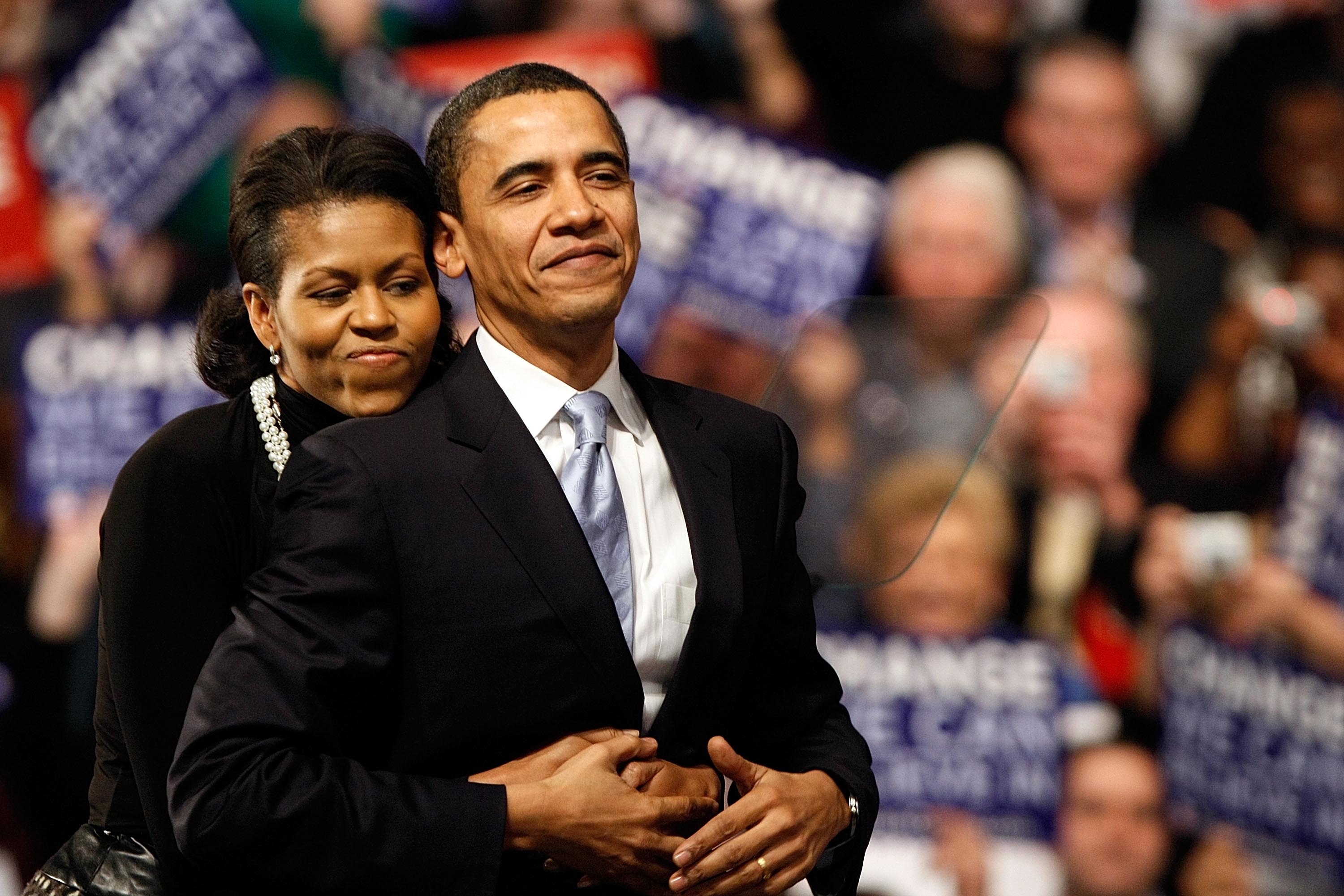 Barack Obama wird von Michelle Obama umarmt, bevor er am 8. Januar 2008 bei einer nächtlichen Grundkundgebung in der Turnhalle der Nashua South High School in Nashua, New Hampshire, eine Rede hält | Quelle: Getty Images