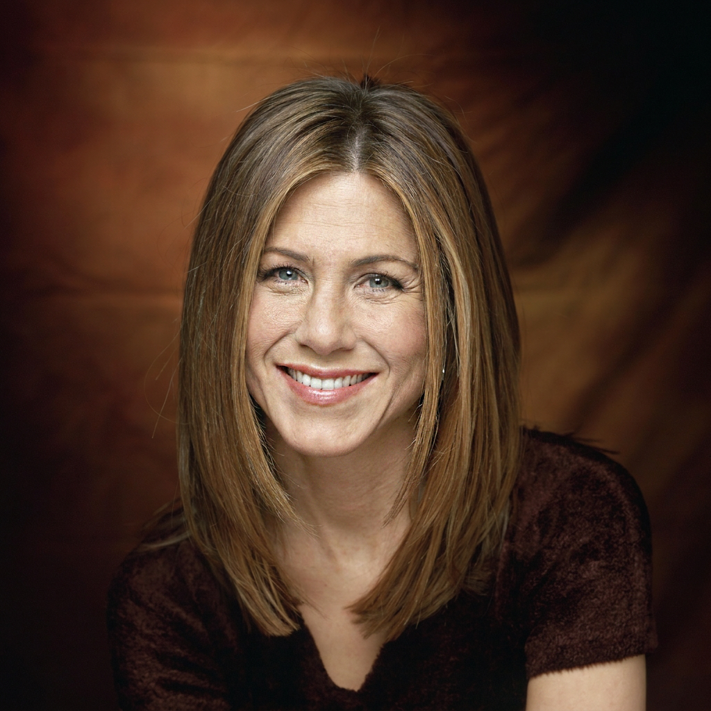 Aniston smiles during a studio portrait session. This AI-generated image depicts the actress with the shoulder-length hairstyle that became one of her most recognizable looks. | Source: Gemini