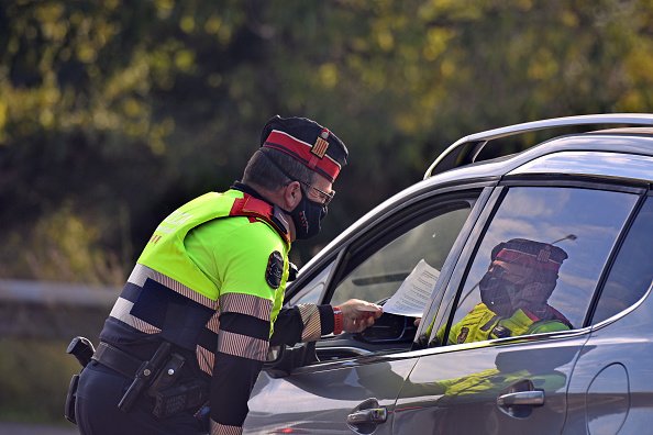 Un policier de Catalogne inspecte le certificat de mobilité d'un conducteur. | Photo : Getty Images