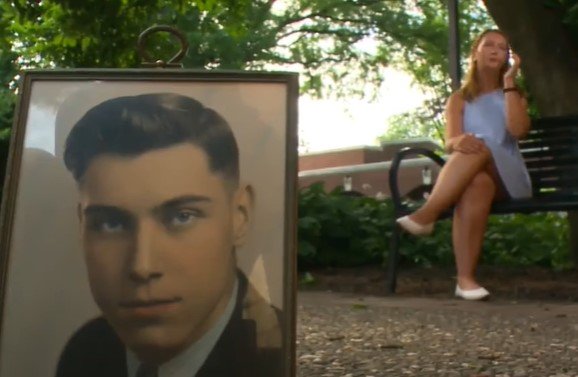 Kira Conrad and a photo frame showing a young Dale Schroeder  | Source: YouTube / KCCI