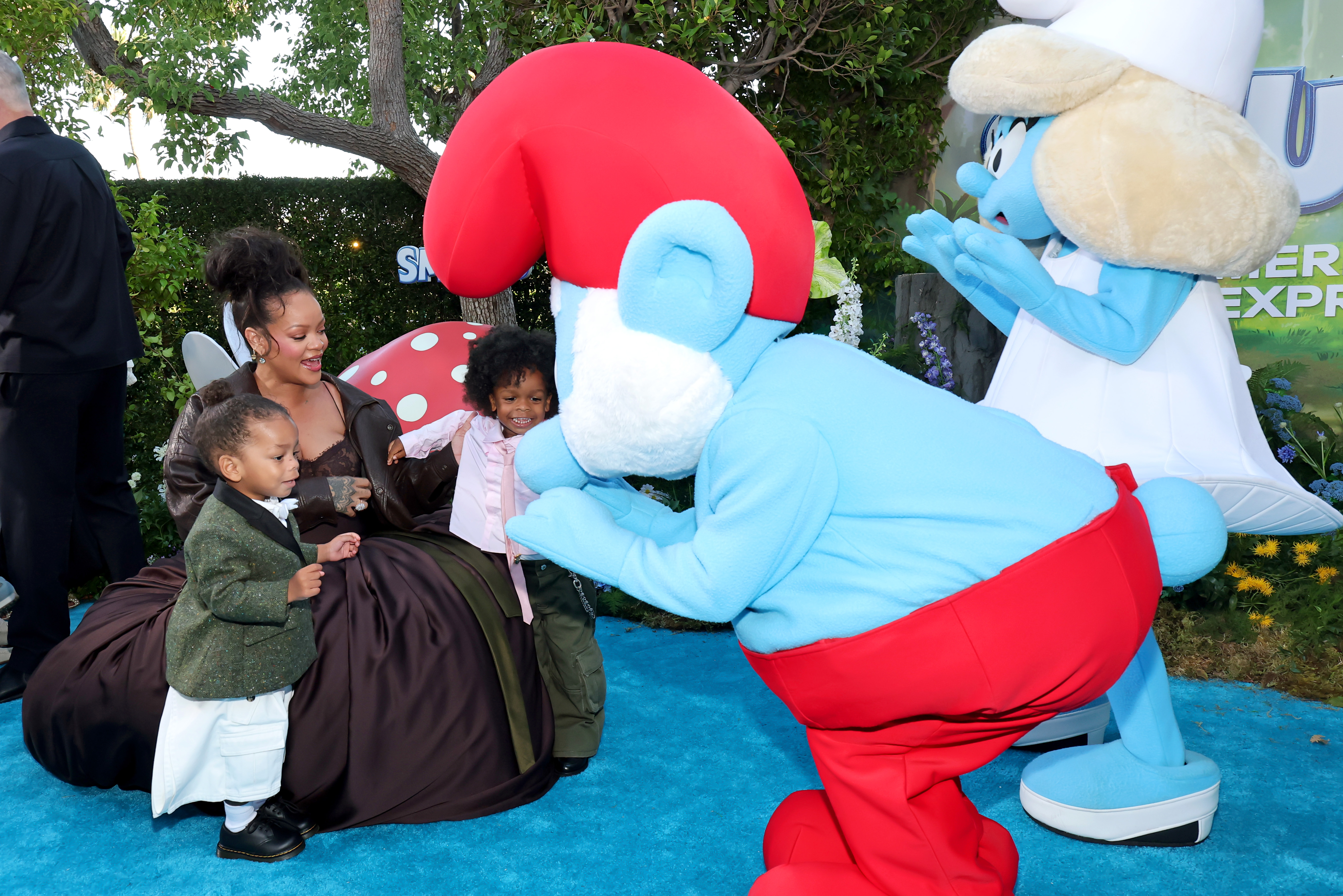 Rihanna and her sons Riot Rose Mayers and RZA Athelston Mayers interacting with costumed Smurf characters | Source: Getty Images