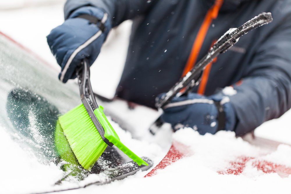 Persona retirando la nieve bajo el limpiaparabrisas. | Foto: Shutterstock