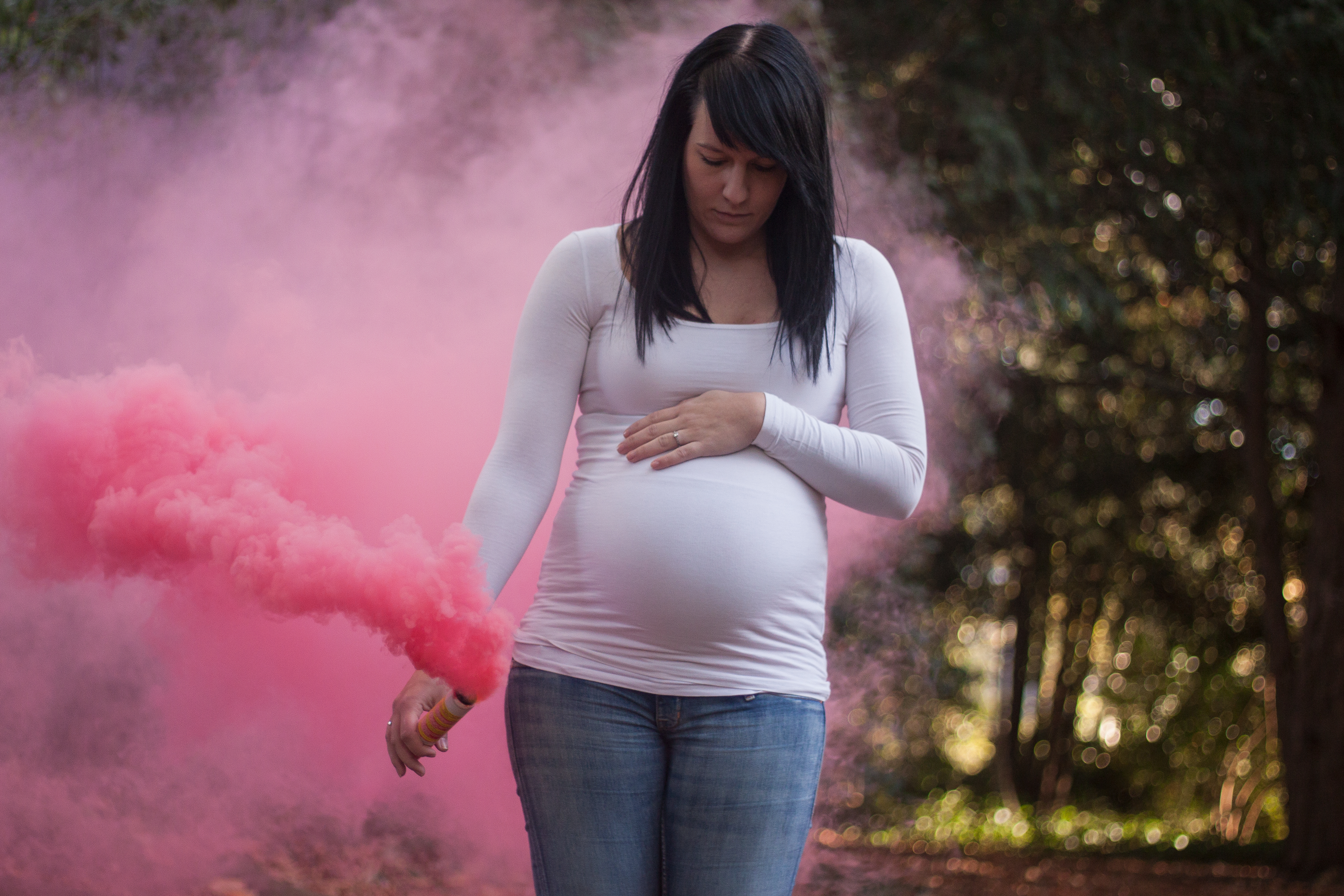 A pregnant woman surrounded by pink smoke | Source: Shutterstock