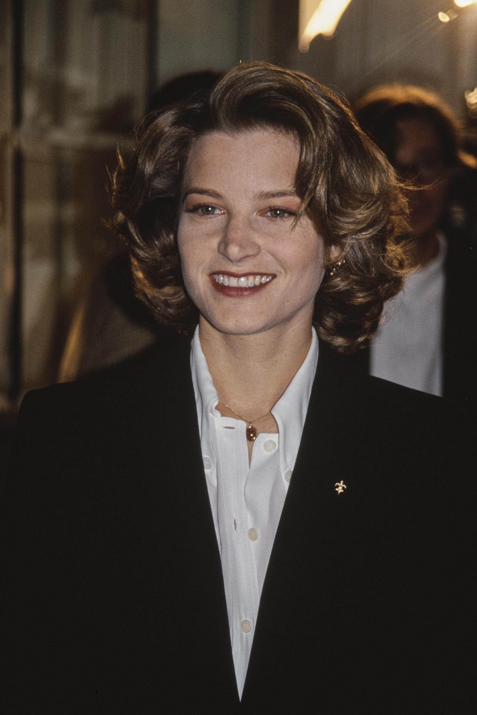 Bridget Fonda attended the 52nd Annual Golden Apple Awards in Beverly Hills on December 13, 1992, wearing a crisp white blouse and tailored black blazer. Her signature voluminous curls and radiant smile completed the polished, confident look that defined her early '90s red carpet style.