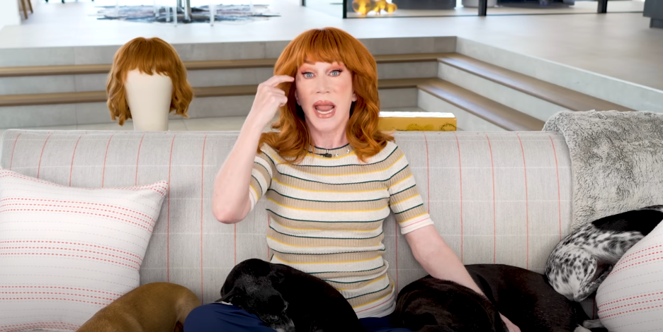 Kathy Griffin pointing to her eyes while sitting on a coach with her pets on an episode of "Talk Your Head Off" dated August 5, 2025 | Source: Youtube/Kathy Griffin