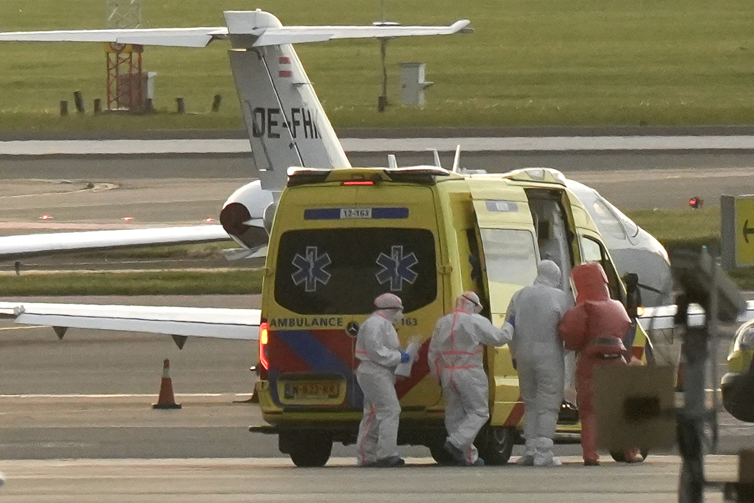 A person in a hazmat suit (2R) is escorted to a ambulance from a medical aircraft allegedly carrying some of the passengers from the cruise ship MV Hondius believed to be infected with hantavirus, at Schiphol airport near Amsterdam on May 6, 2026 | Source: Getty Images