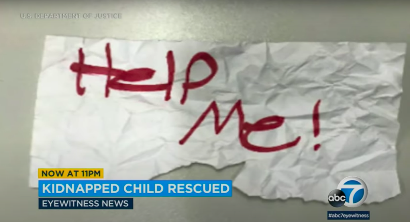 Ein Screenshot des ""Hilf mir"-Schildes, das das Mädchen hochhielt, gepostet am 21. Juli 2023 | Quelle: YouTube/ABC7