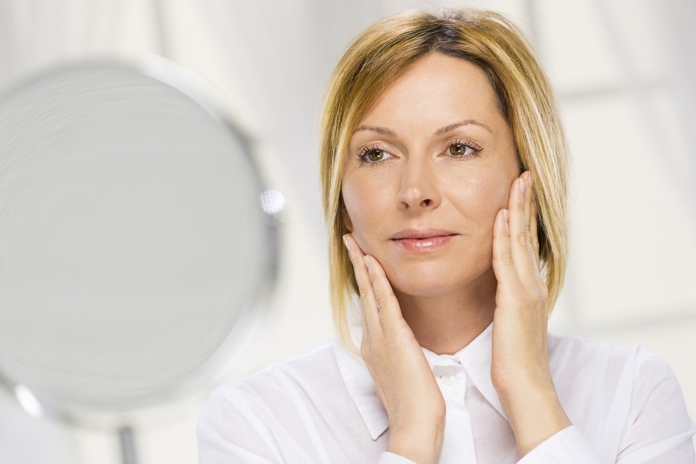 Mujer de 40 mirándose en un espejo. | Foto: Shutterstock