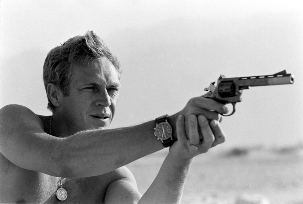 Actor Steve McQueen holding a pistol and taking aim in a desert area around Palm Springs, California in June 1963. | Photo: Getty Images