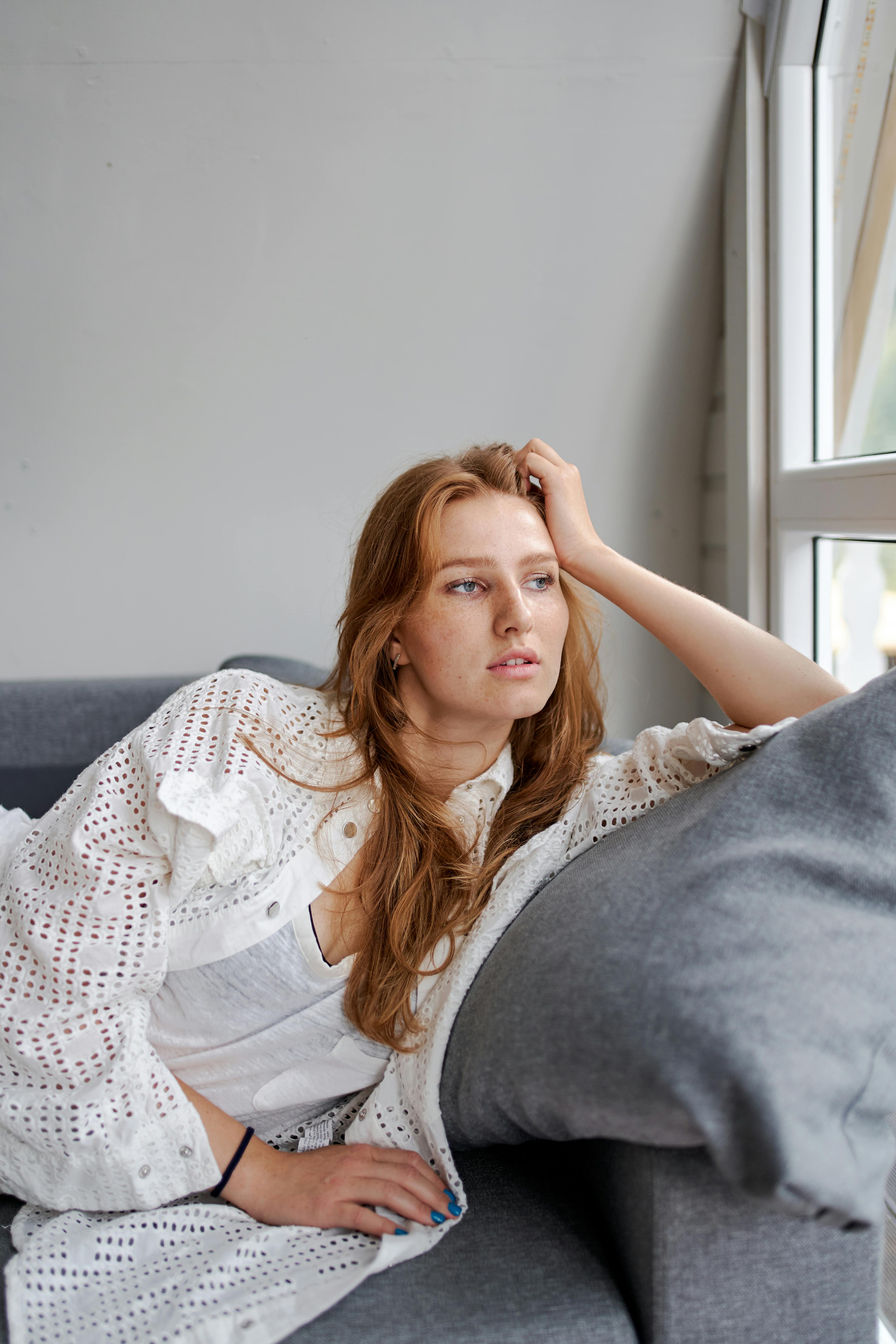 A worried woman on a couch | Source: Pexels