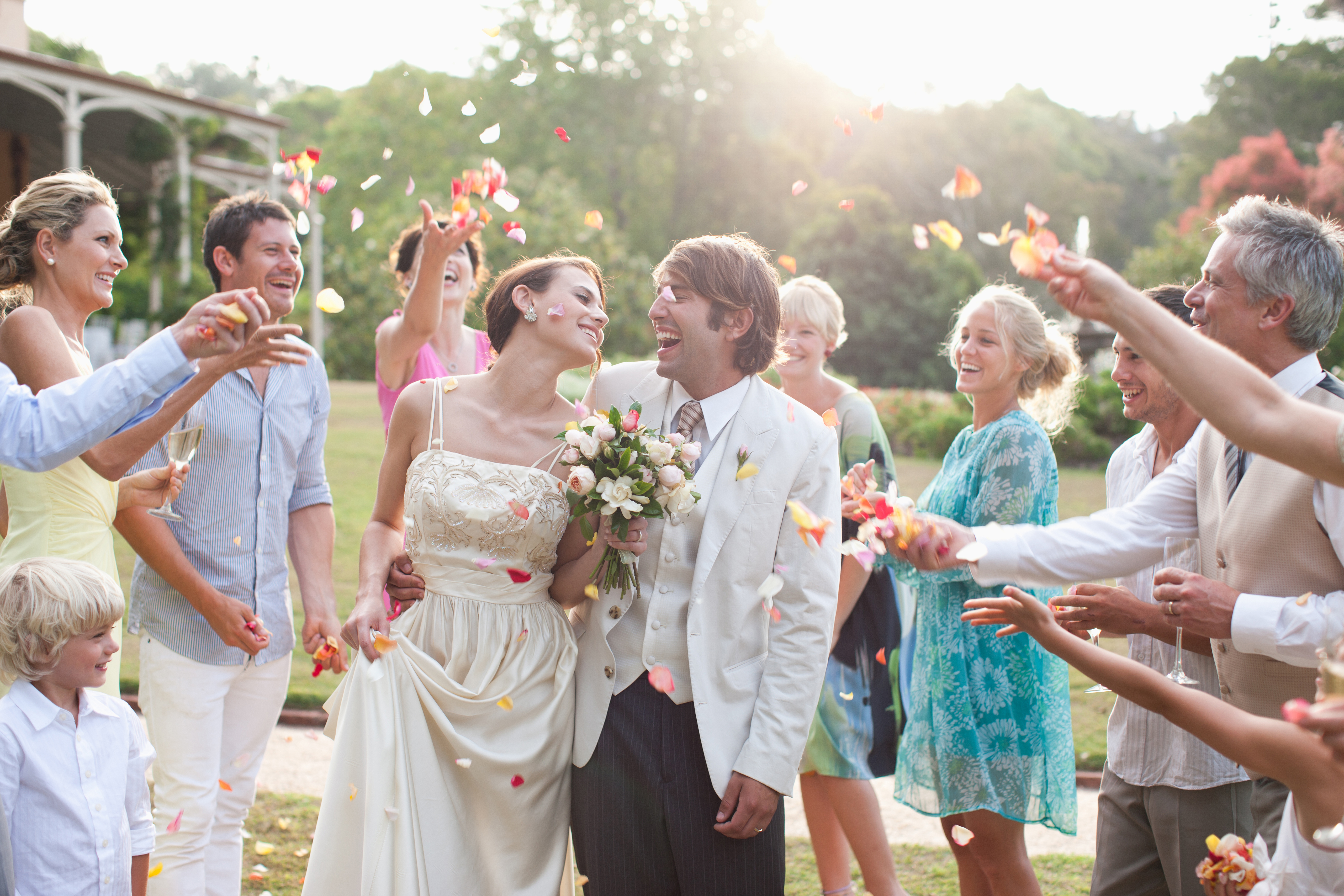 Guests throwing rose petals on bride and groom | Source: Getty Images