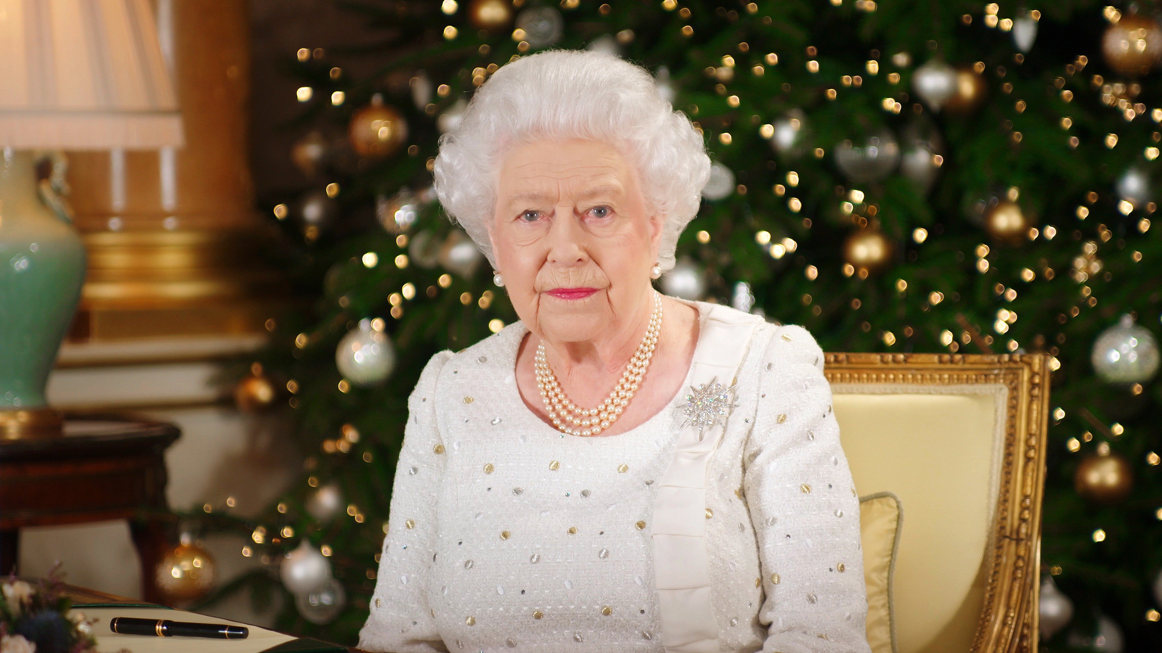 La reina Isabel II se sienta en un escritorio en la Sala 1844 en el Palacio de Buckingham mientras graba su transmisión del día de Navidad a la Commonwealth en el Palacio de Buckingham, Londres. | Foto: Getty Images