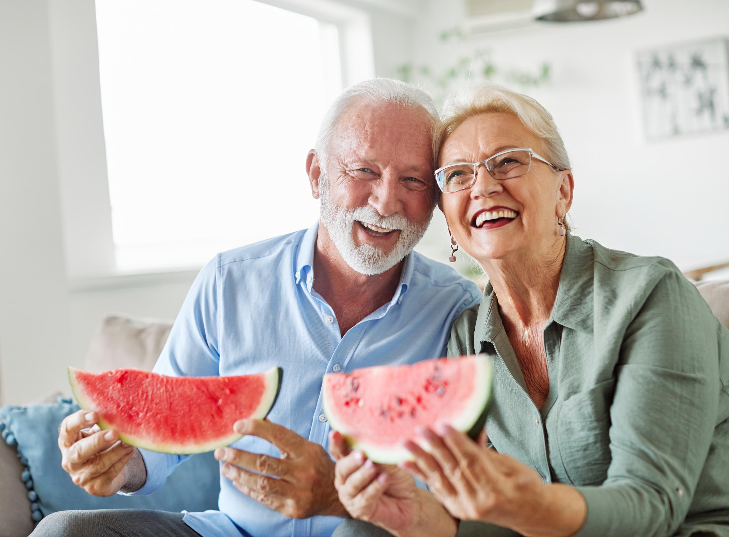 An elderly couple enjoying watermelon | Source: Shutterstock