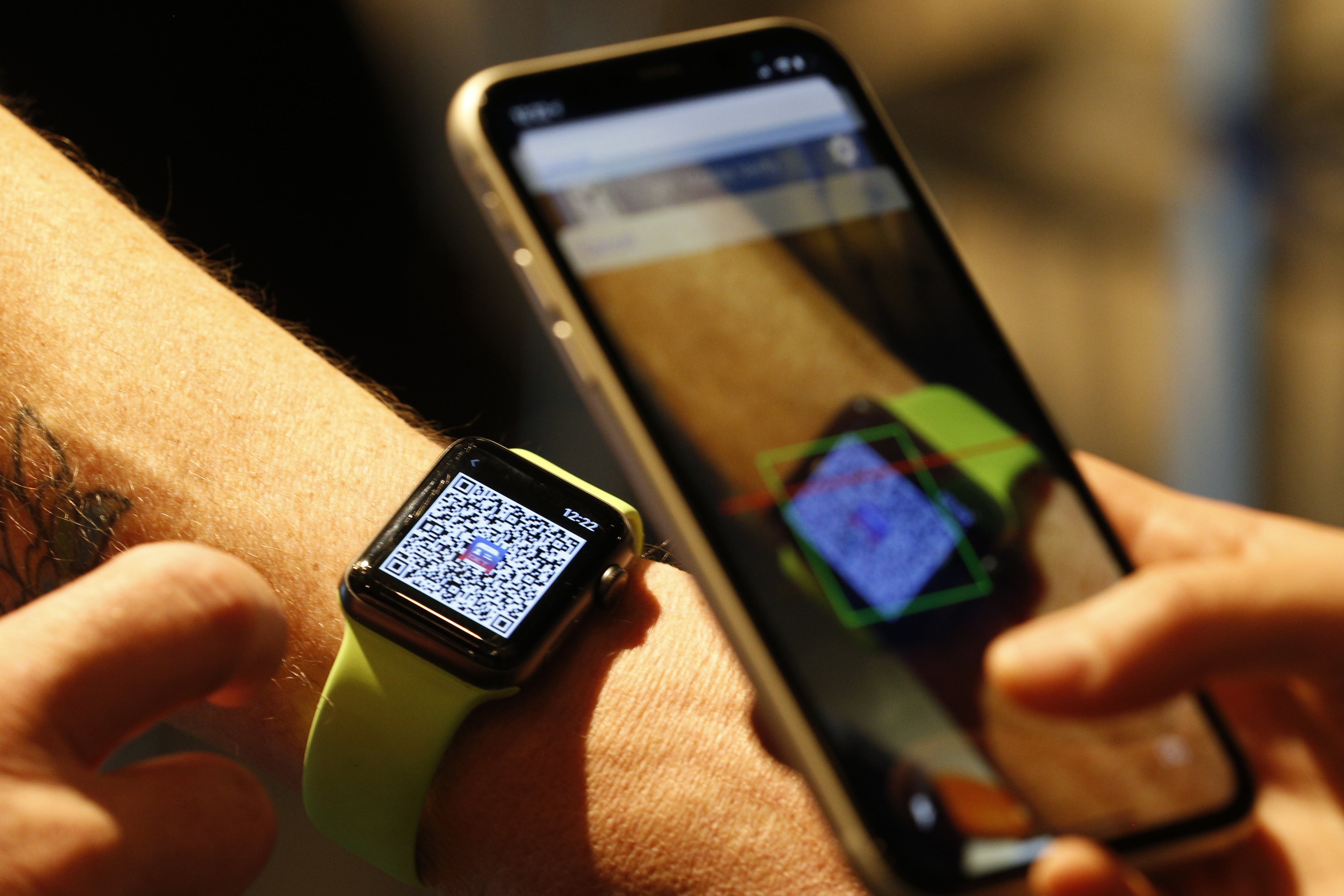 Une personne scanne un code QR sur une Apple Watch.| Photo : Getty Images