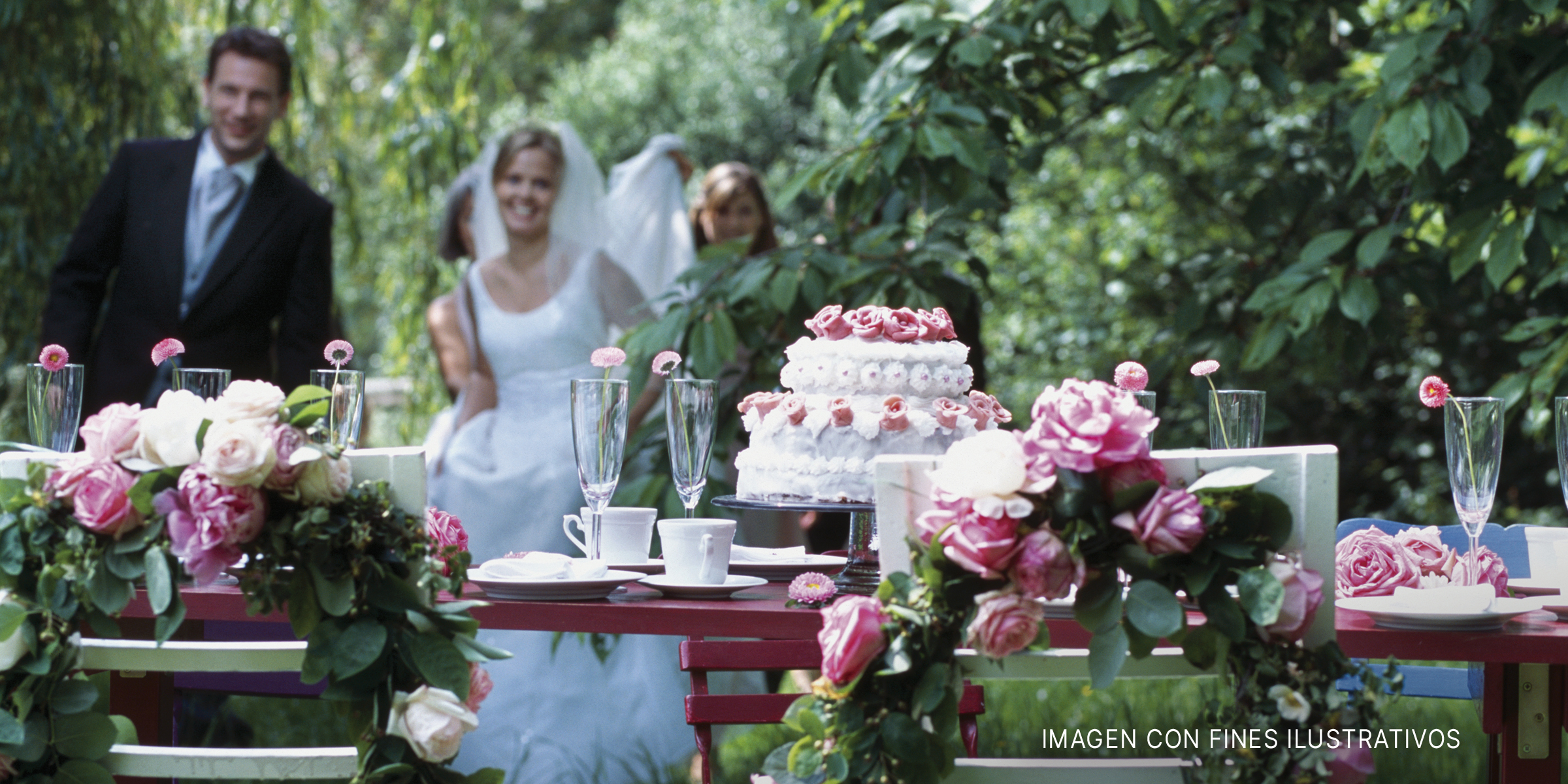 Novia y novio se aproximan a un pastel de bodas. | Foto: Getty Images