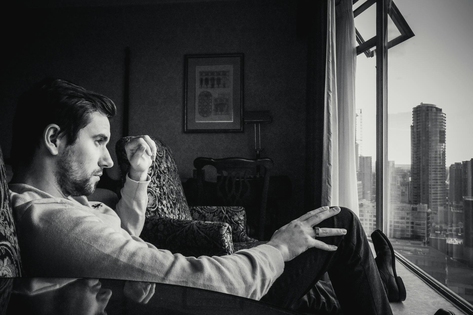A grayscale photo of a man looking at the window | Source: Pexels