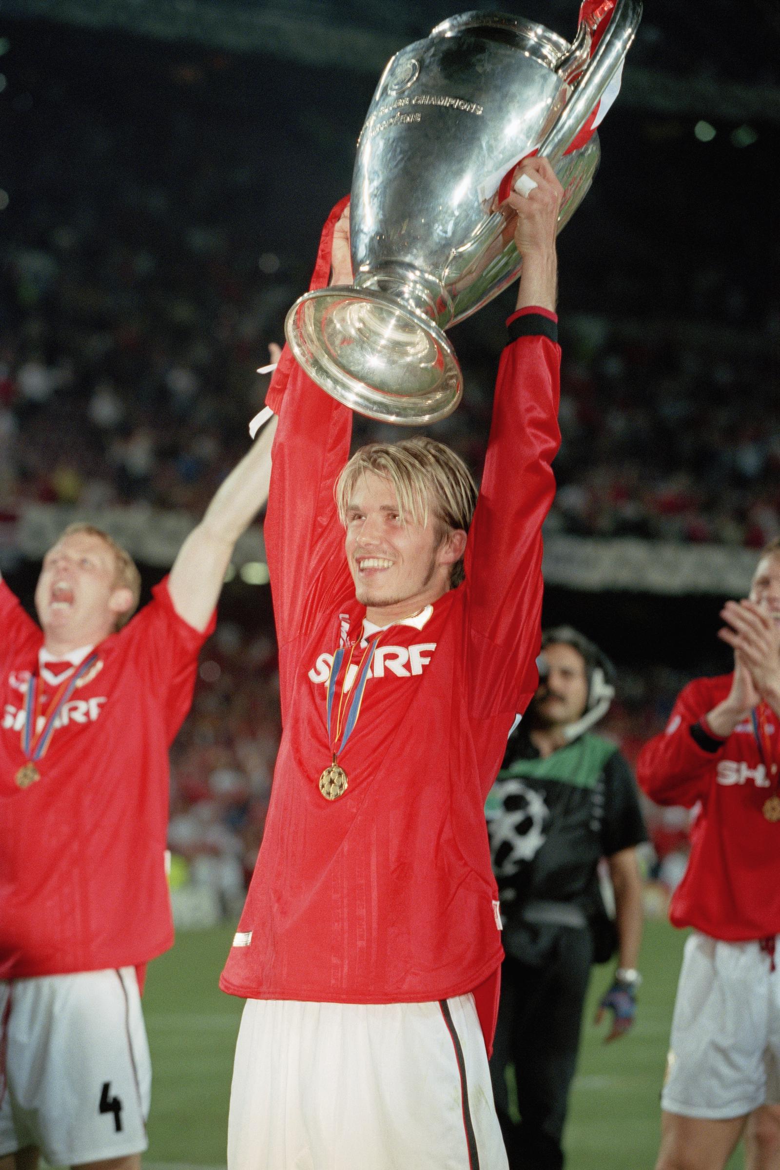 David Beckham hoists the trophy aloft after the 1998-1999 Champions League final won by Manchester United (2-1) on 26 May 1999 in Barcelona, Spain. | Source: Getty Images