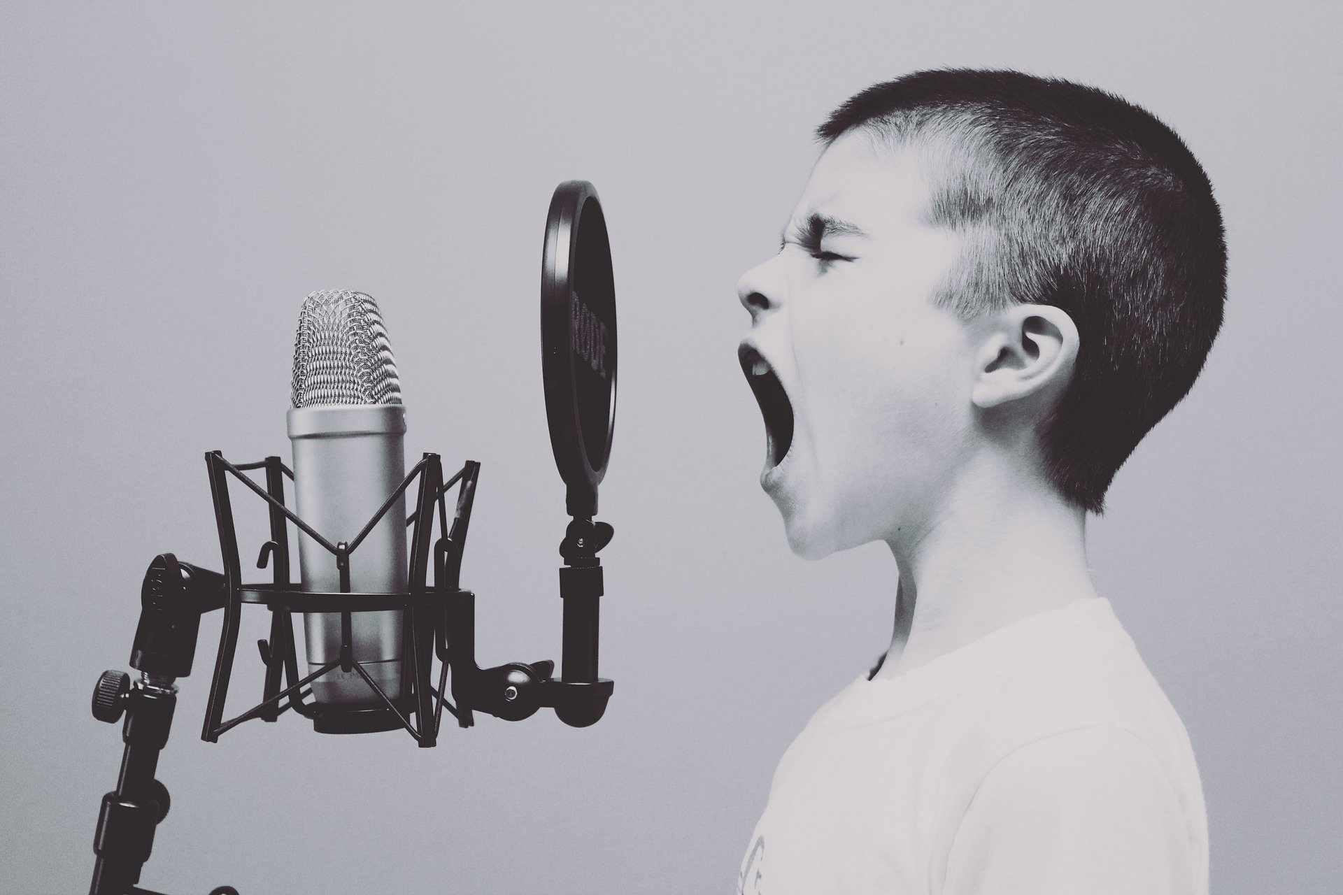 A young boy screaming into a microphone in a studio. | Source: Pixabay.
