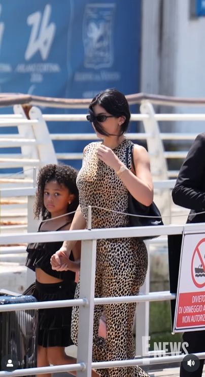 Stormi Webster looks straight at the camera with a calm expression while walking beside her mother, Kylie Jenner, posted on June 30, 2025 | Source: Instagram/enews