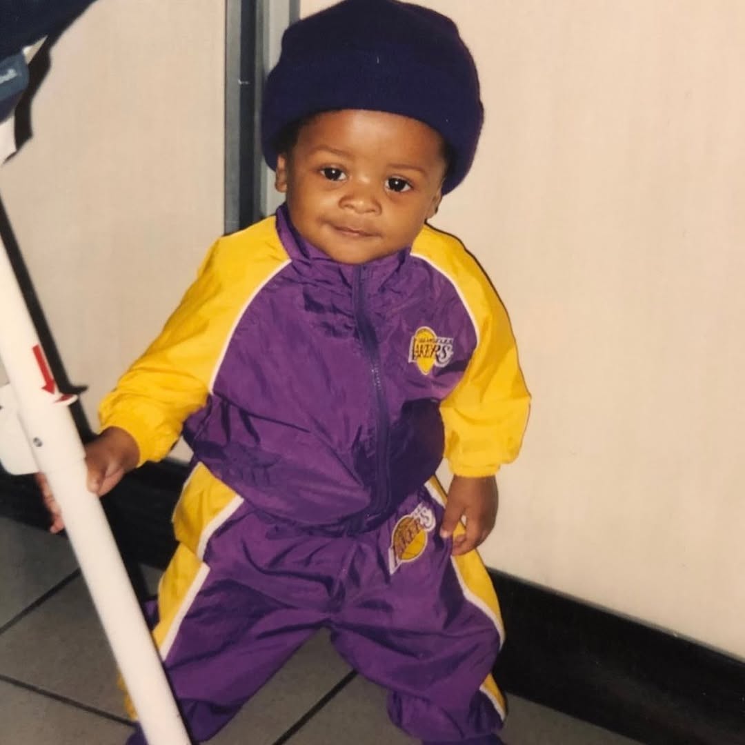 A young Blake Underwood poses as a toddler in a purple and gold tracksuit, standing confidently and offering an early glimpse of his playful personality. | Source: Instagram/blairunderwood_official