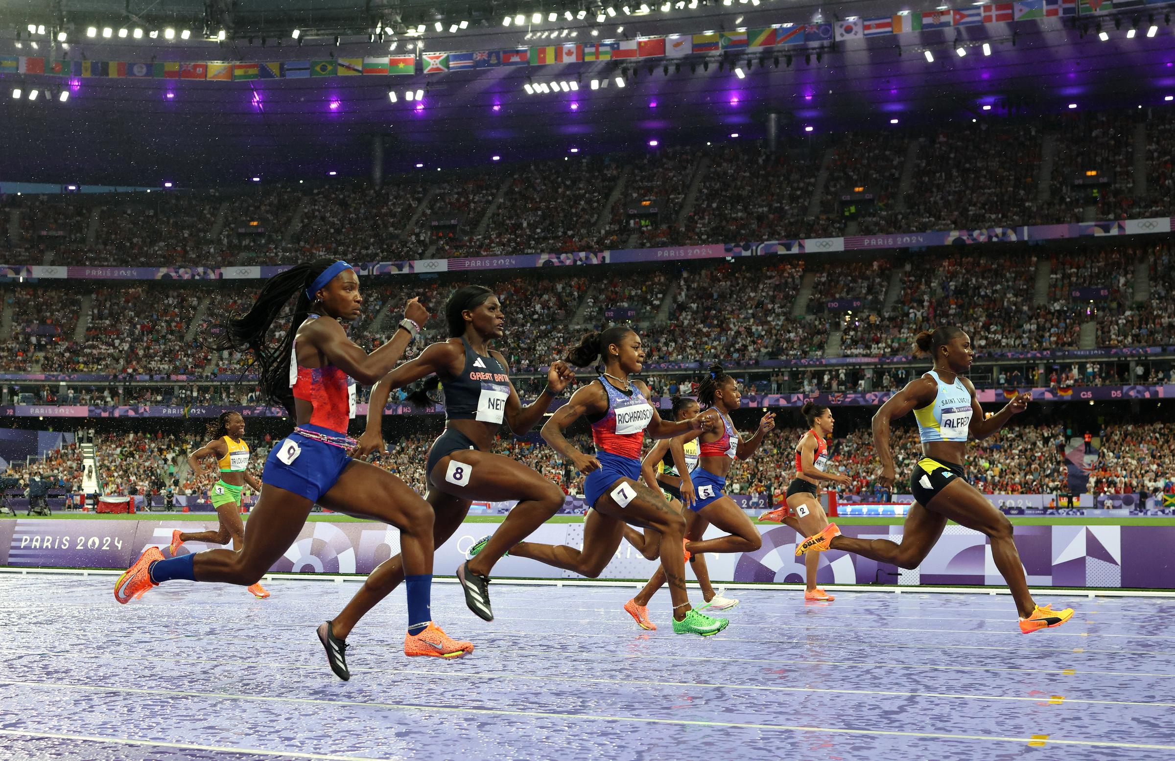 Sha'Carri Richardson and Julien Alfred racing alongside fellow female athletes in the women's 100m semifinals during the Paris Olympics in Paris, France on August 3, 2024 | Source: Getty Images