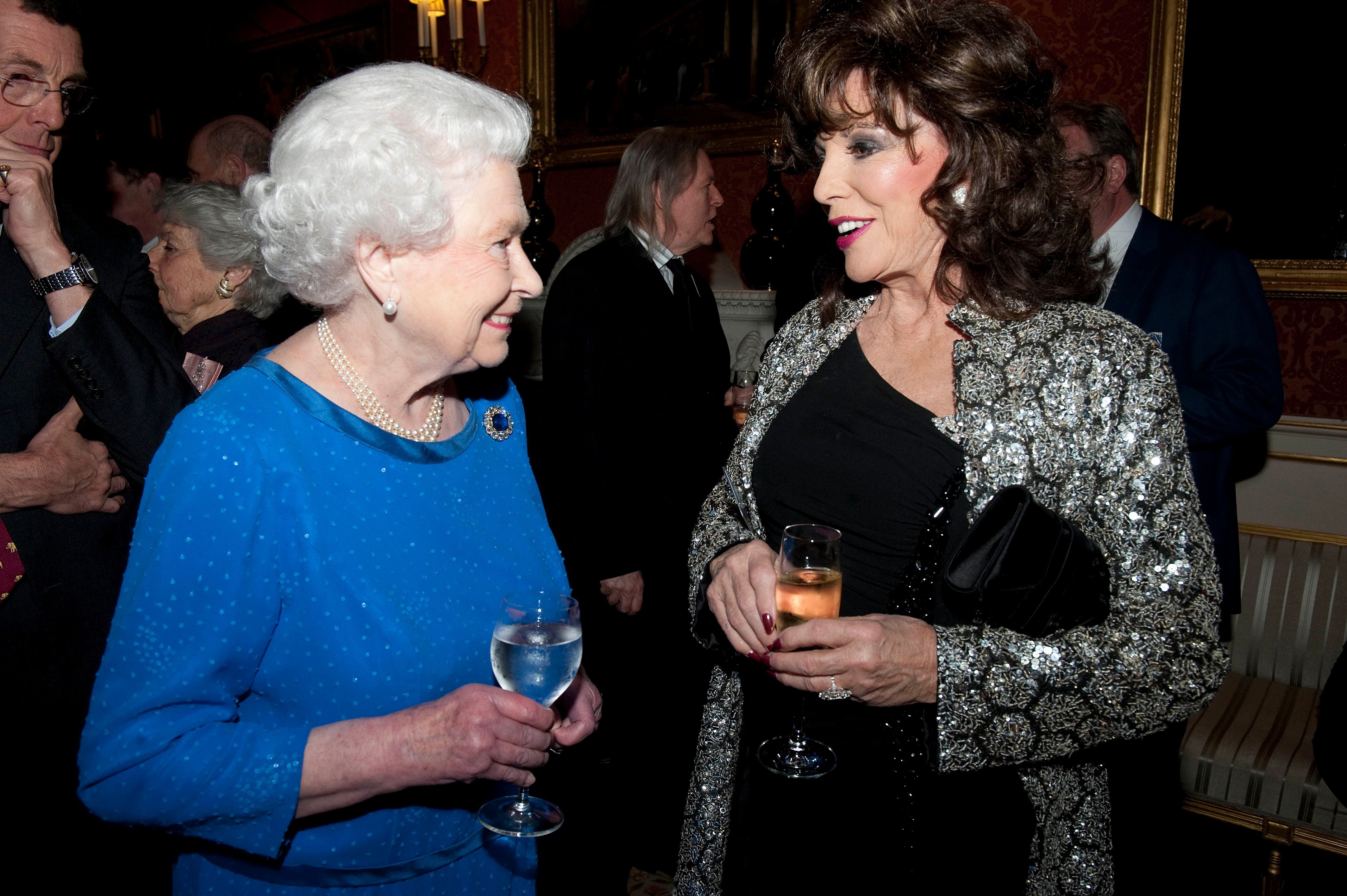 Queen Elizabeth II and Joan Collins at the Dramatic Arts reception at Buckingham Palace on February 17, 2014 | Photo: Getty Images