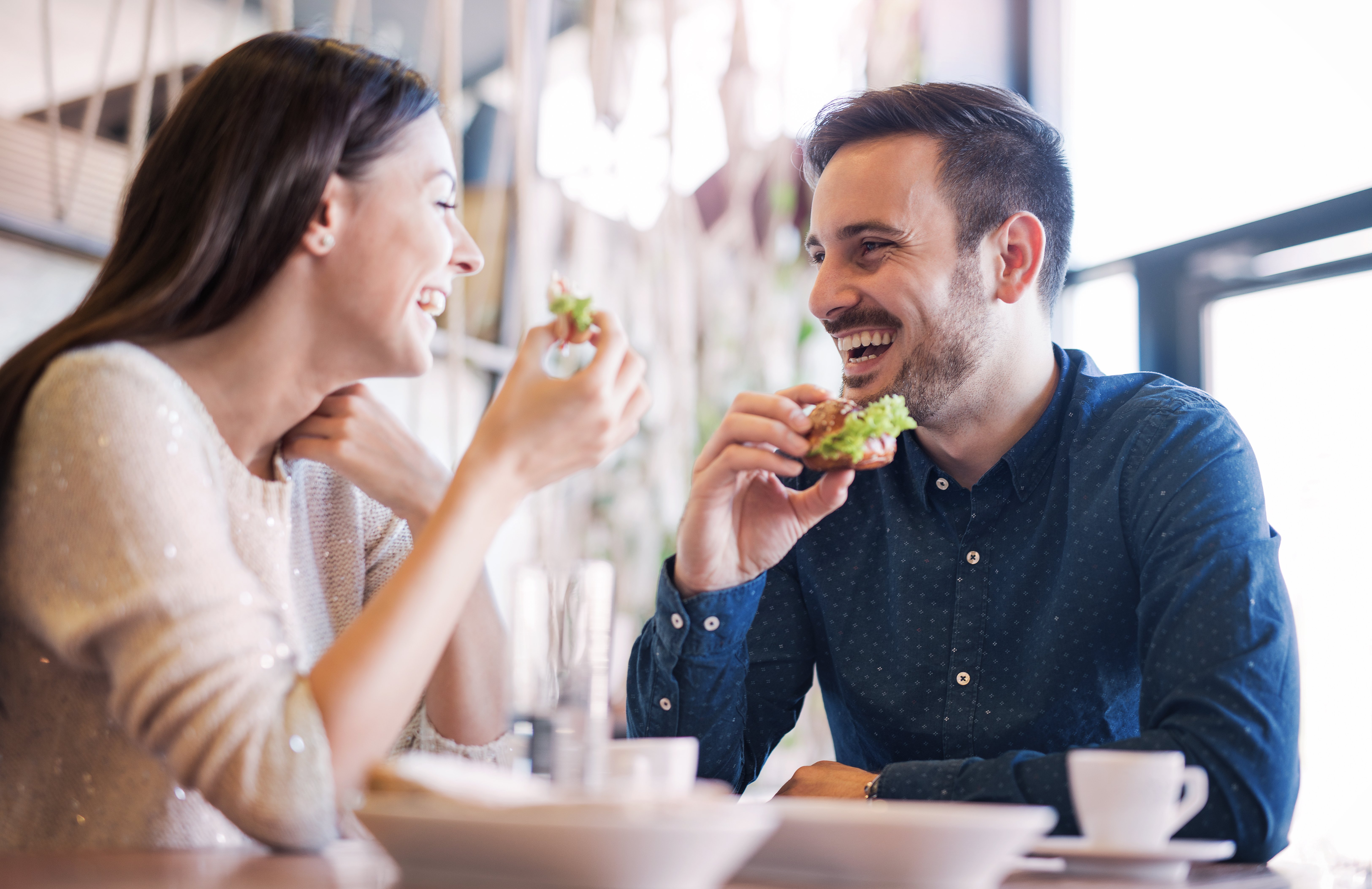 Glückliches Liebespaar, das Frühstück in einem Café genießt | Quelle: Shutterstock