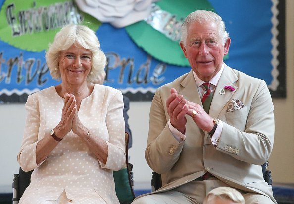 Prince Charles, The Prince of Wales and Camilla, the Duchess of Cornwall applaud after listening to the Aloud charity choir during a visit to White Rose Primary School  in Elliots Town.| Photo: Getty Images.