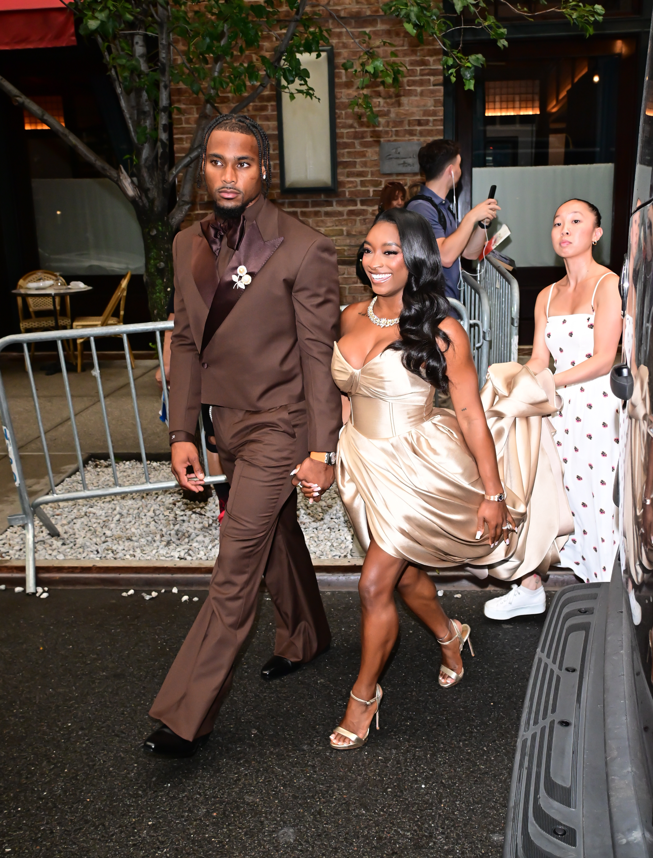 This candid moment captured the couple making their way through the city after the event. With Owens leading the way and Biles smiling beside him, the image adds context beyond the still expressions that fueled so much discussion online. | Source: Getty Images