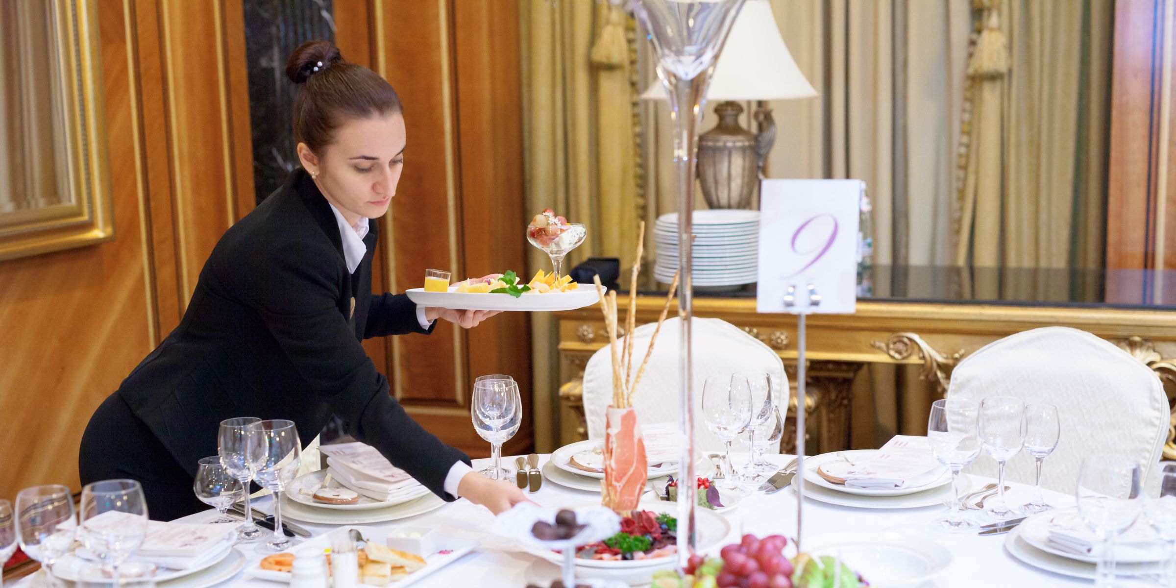 A waitress serving a table at a wedding banquet | Source: Shutterstock