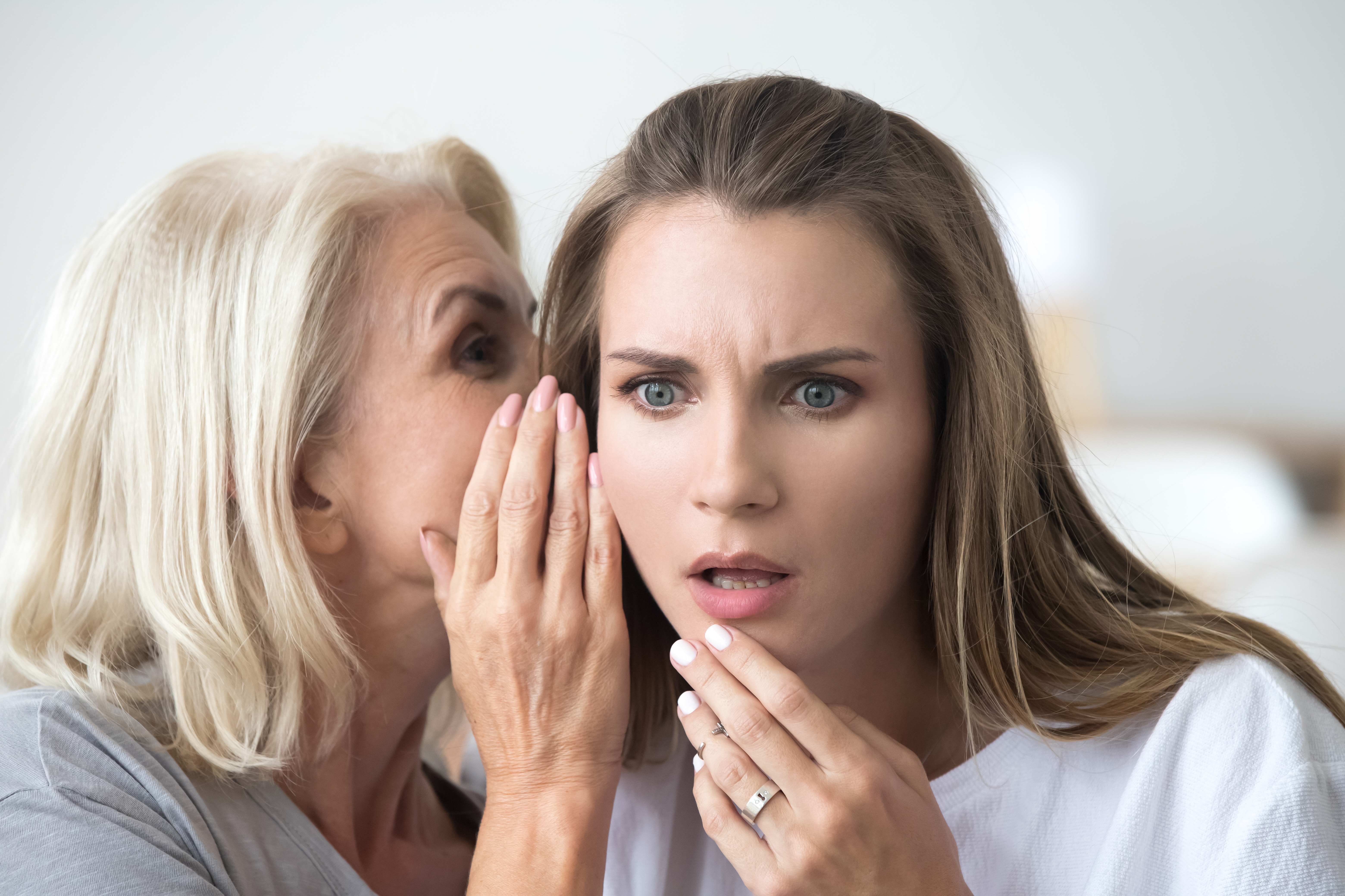 Two women sharing a secret | Source: Shutterstock