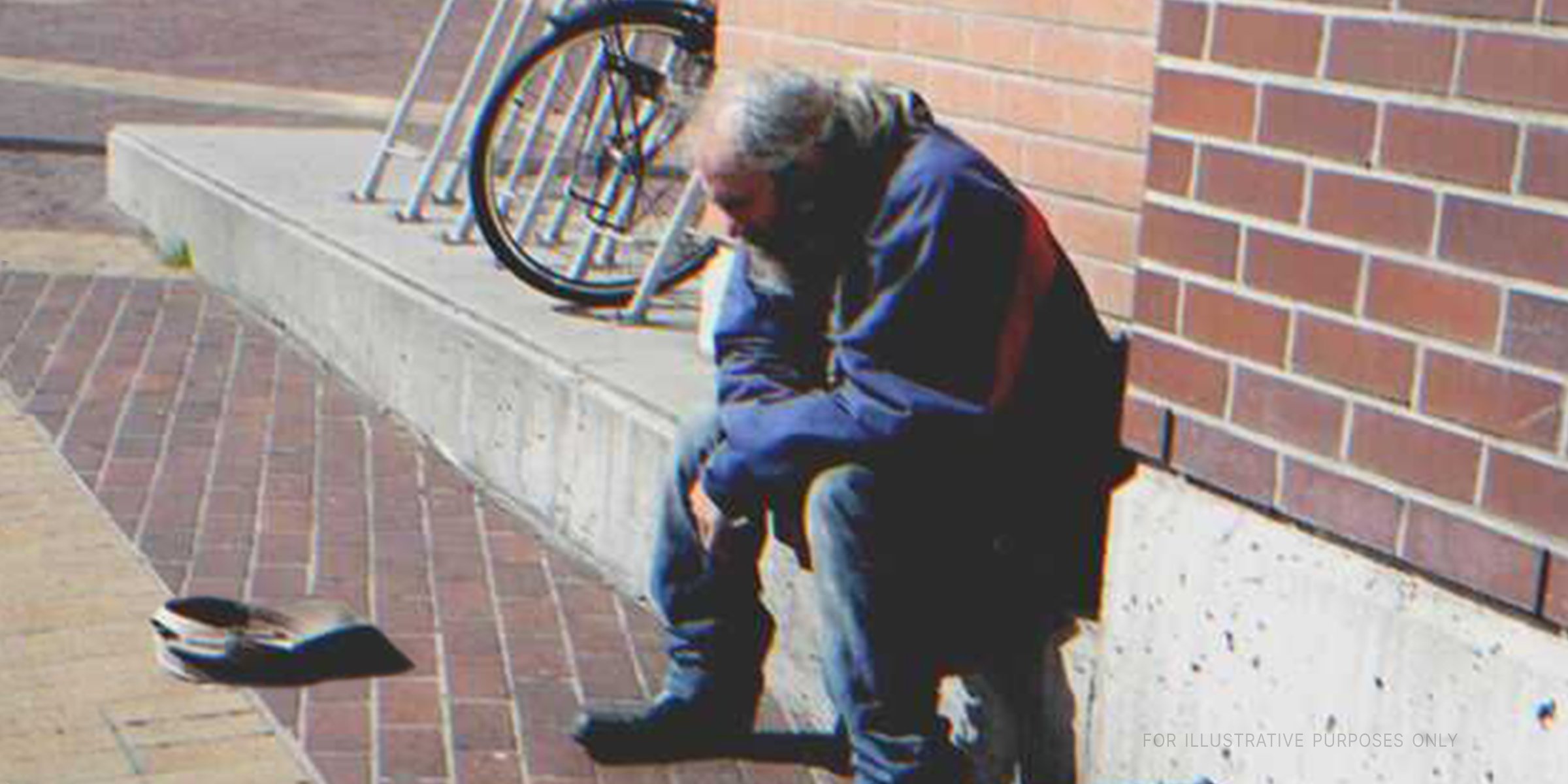 Anciano sentadio en una acera. | Foto: Flickr.com/flightlog (CC BY 2.0)