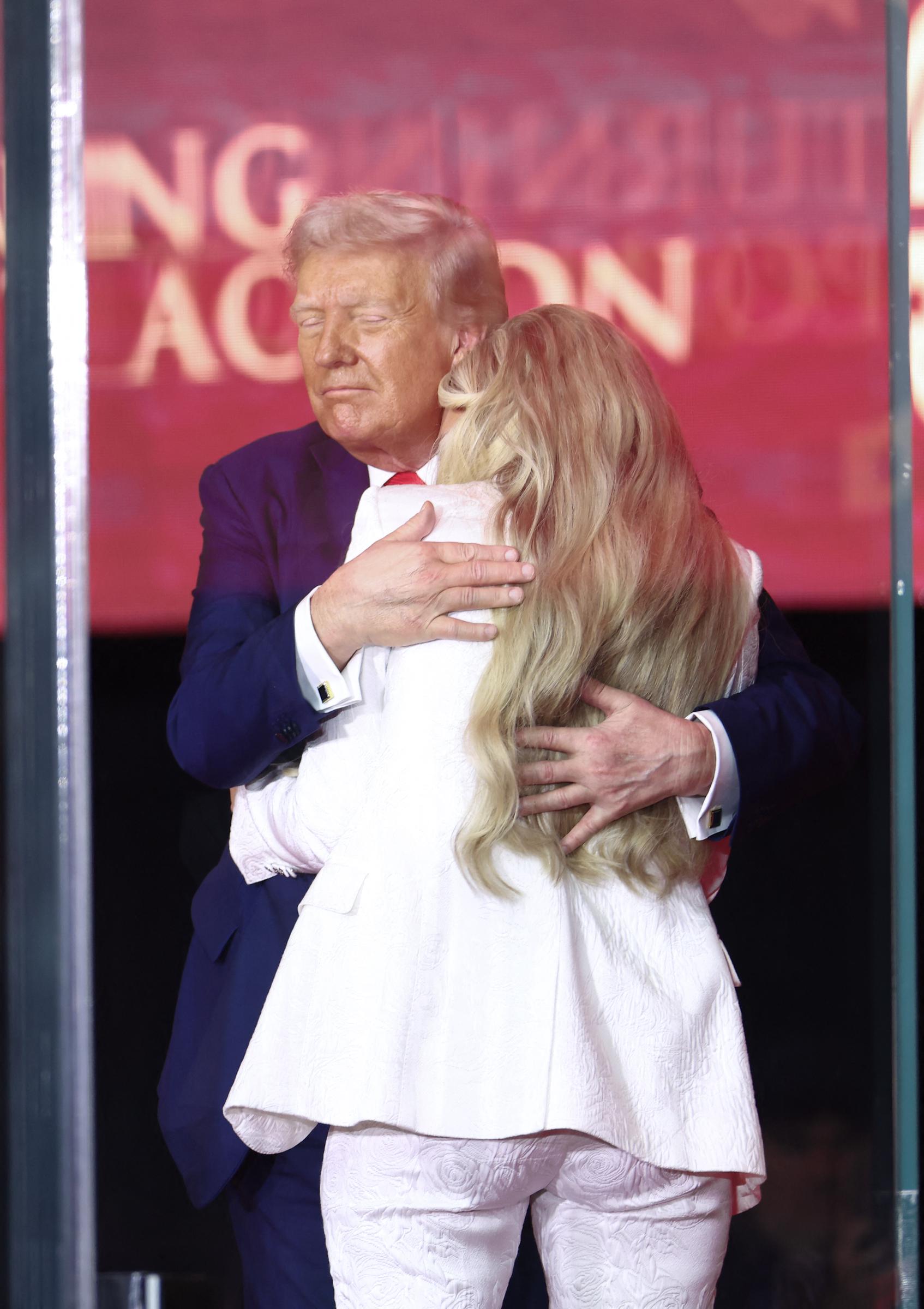 President Donald Trump embraces Erika Kirk onstage during the public memorial service for Charlie Kirk at State Farm Stadium on September 21, 2025 | Source: Getty Images