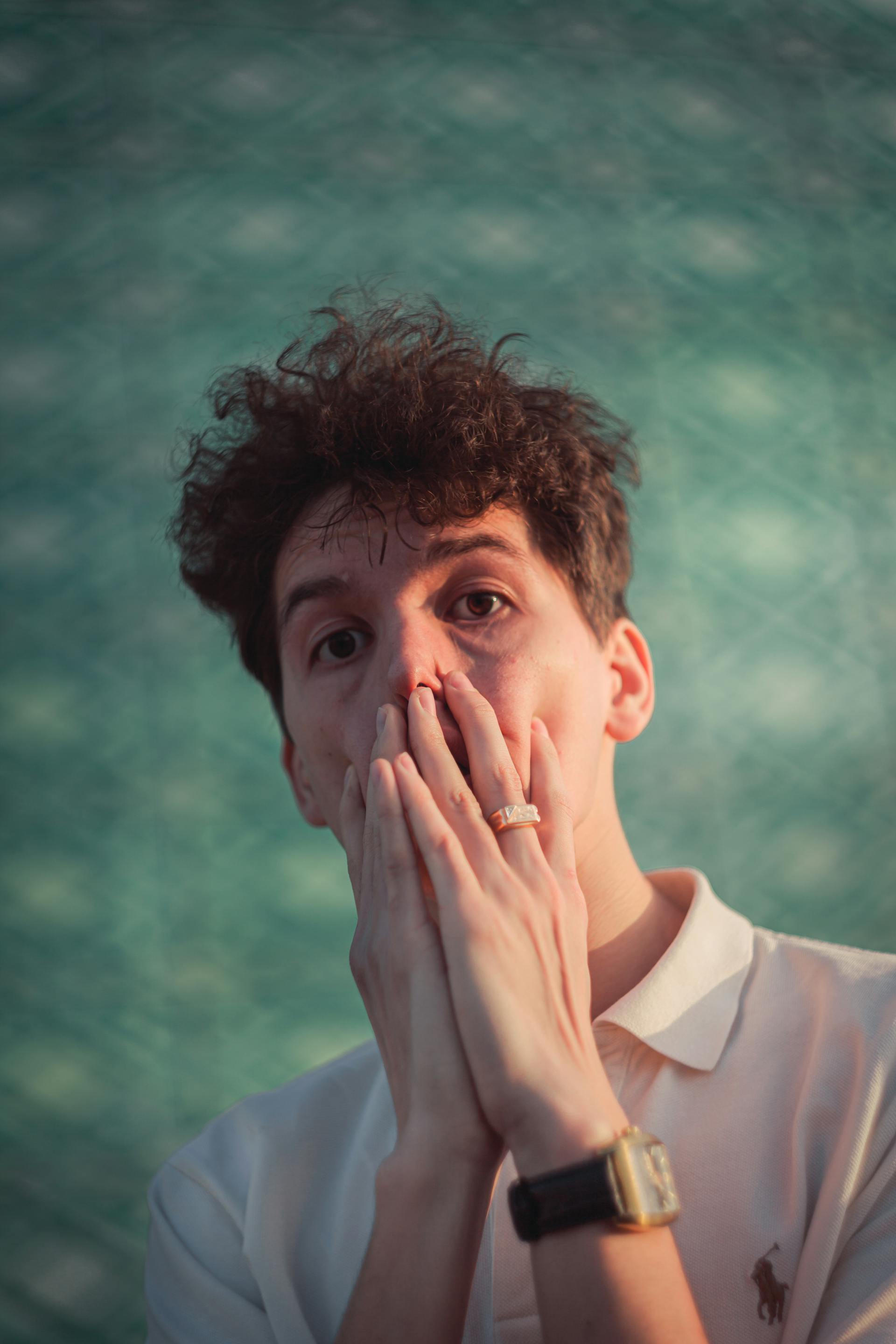 A man covering his mouth with both hands | Source: Pexels