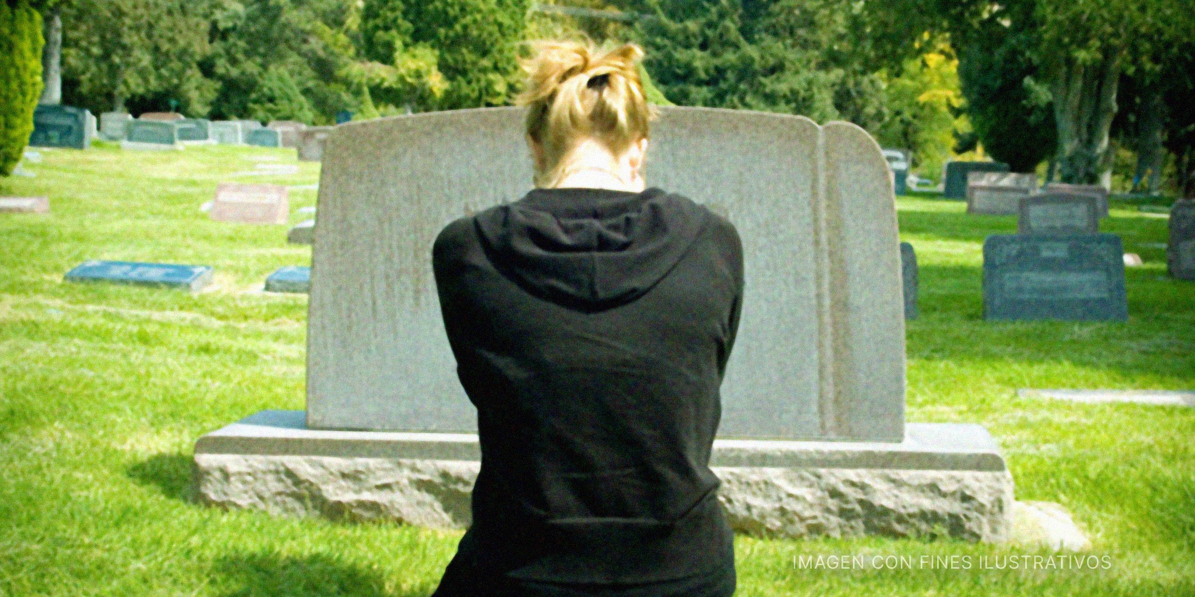Una adolescente visita la tumba de su padre y llora. | Foto: Getty Images