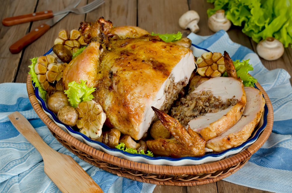 Pollo relleno horneado, servido sobre una cama de vegetales en un cuenco. | Foto: Shutterstock