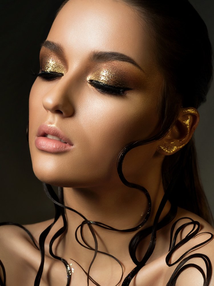 Mujer luciendo las cejas definidas y sombras en tonos dorados y bronce. | Foto: Shutterstock