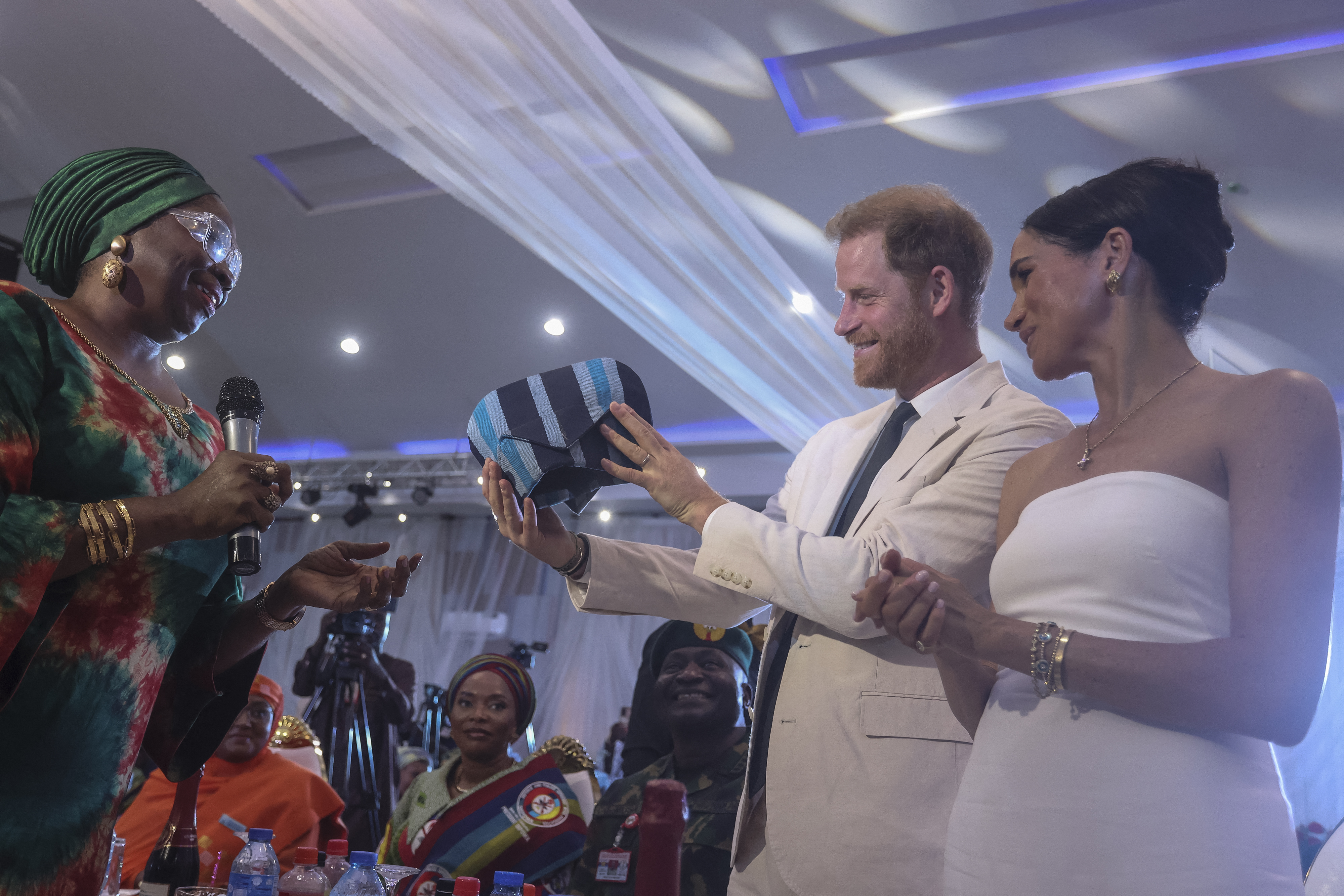Prince Harry and Meghan Markle receive a traditional outfit as they attend a Sit Out at the Nigerian Defence Headquarters in Abuja on May 11, 2024, in Nigeria. | Source: Getty Images