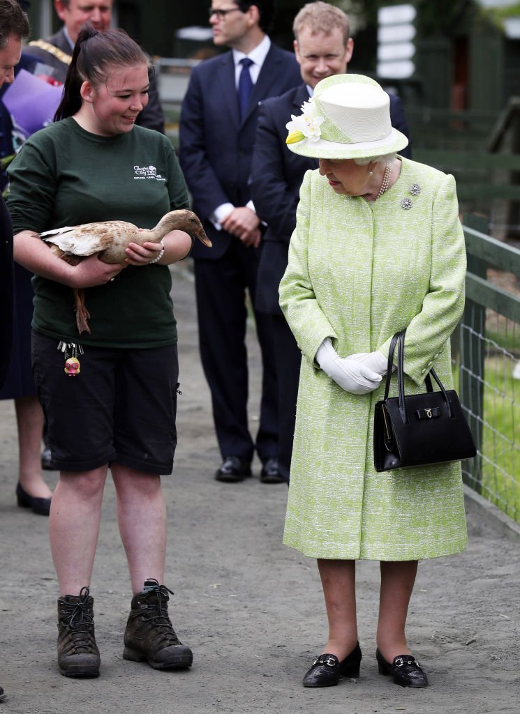 La reine Elizabeth II avec la gardienne Maia Gordon lors d'une visite à la ferme de Gorgie City | Photo : Getty Images