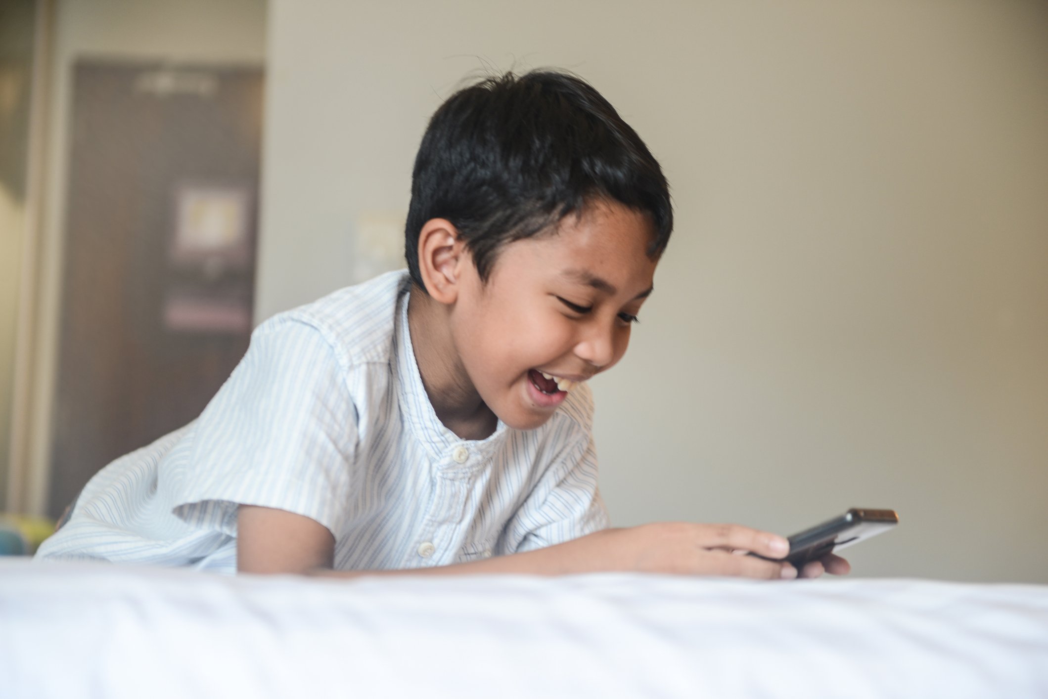 Junge benutzt Smartphone im Hotelzimmer I Quelle: Getty Images